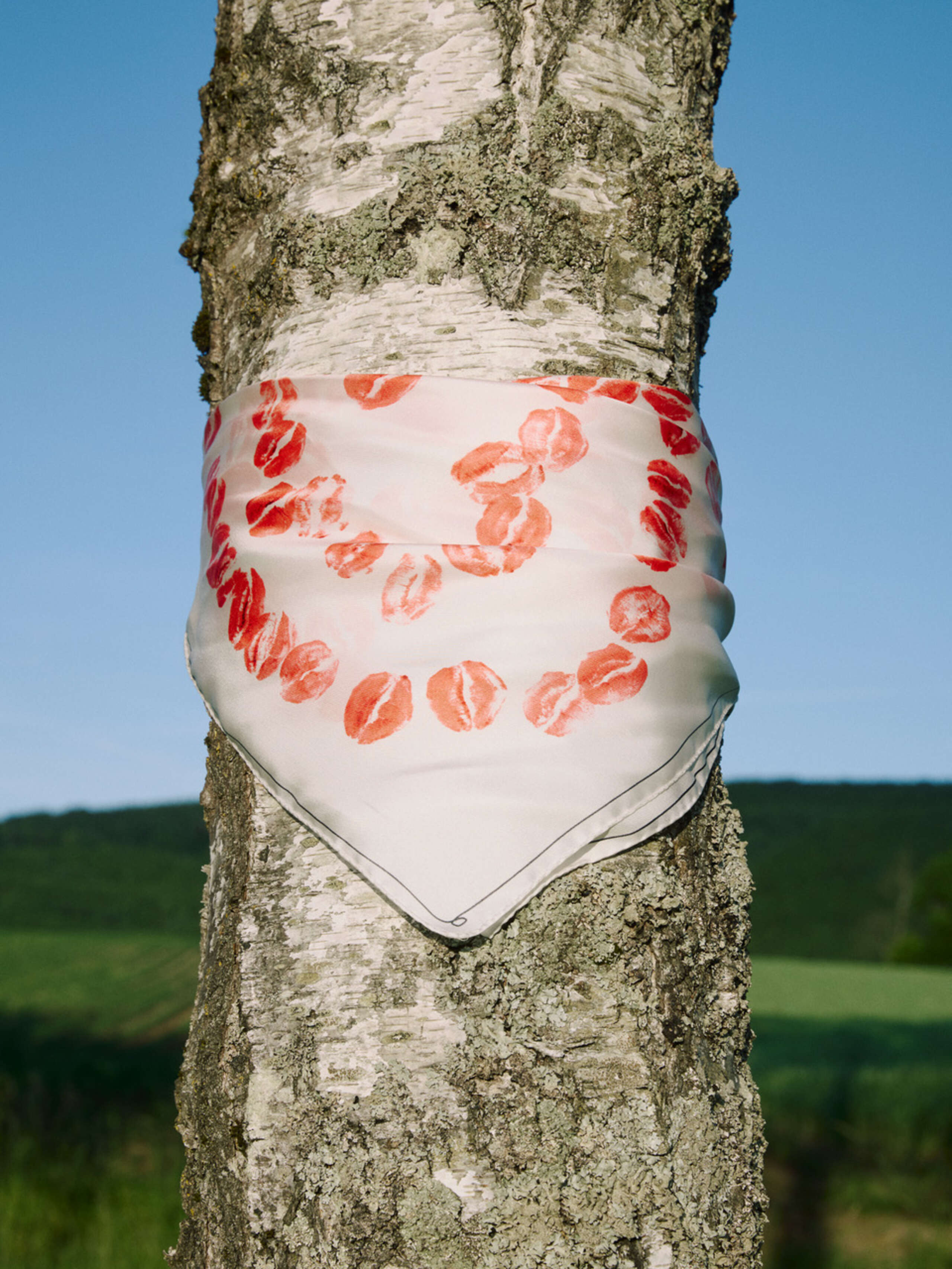Picture of a foulard by artist Bruno Zhu for enSoie and SAALHOF 1123 hanging on a tree.