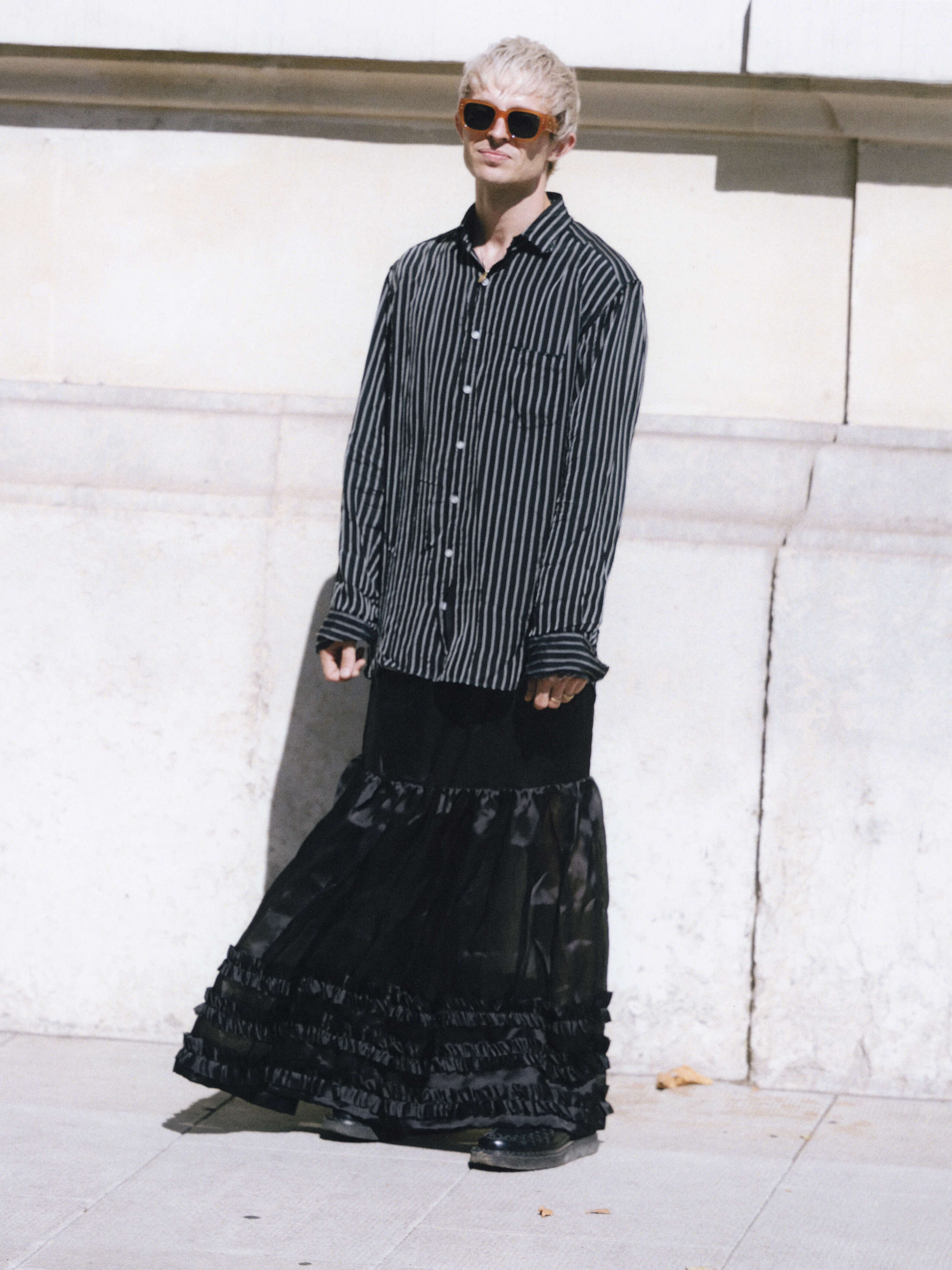 Young man wearing a black skirt and shirt