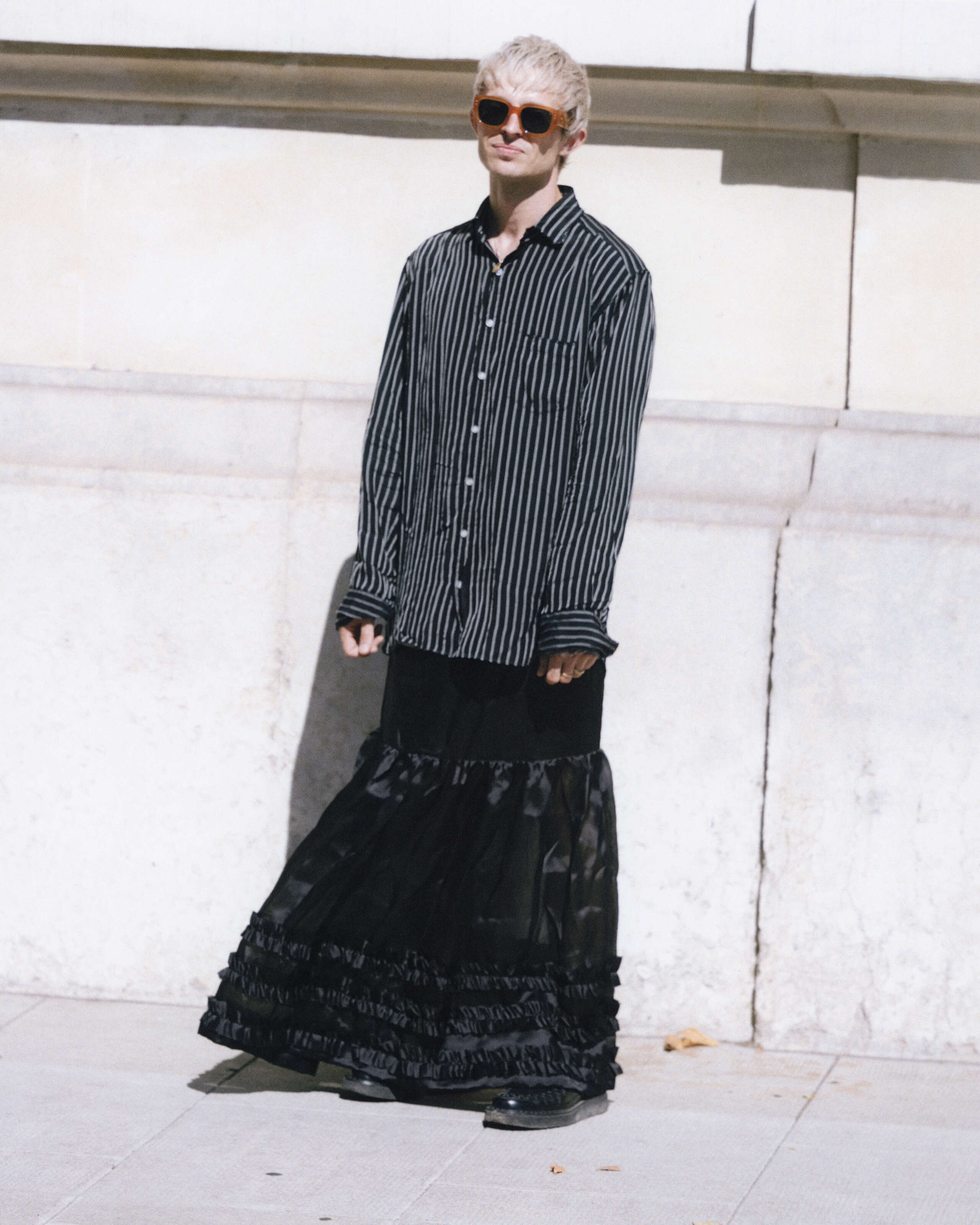 Young man wearing a black skirt and shirt