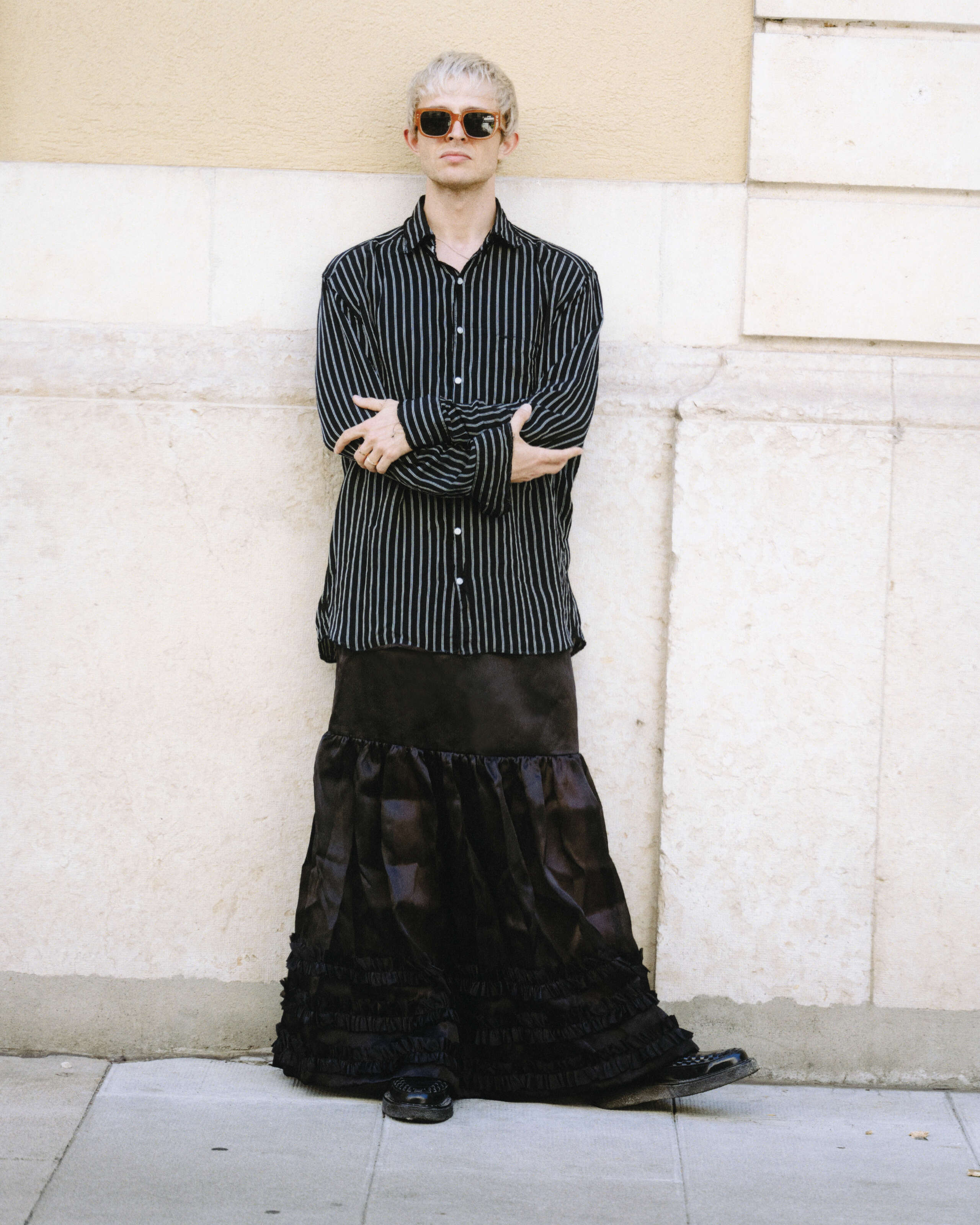 Picture of a young man, wearing a black skirt and shirt