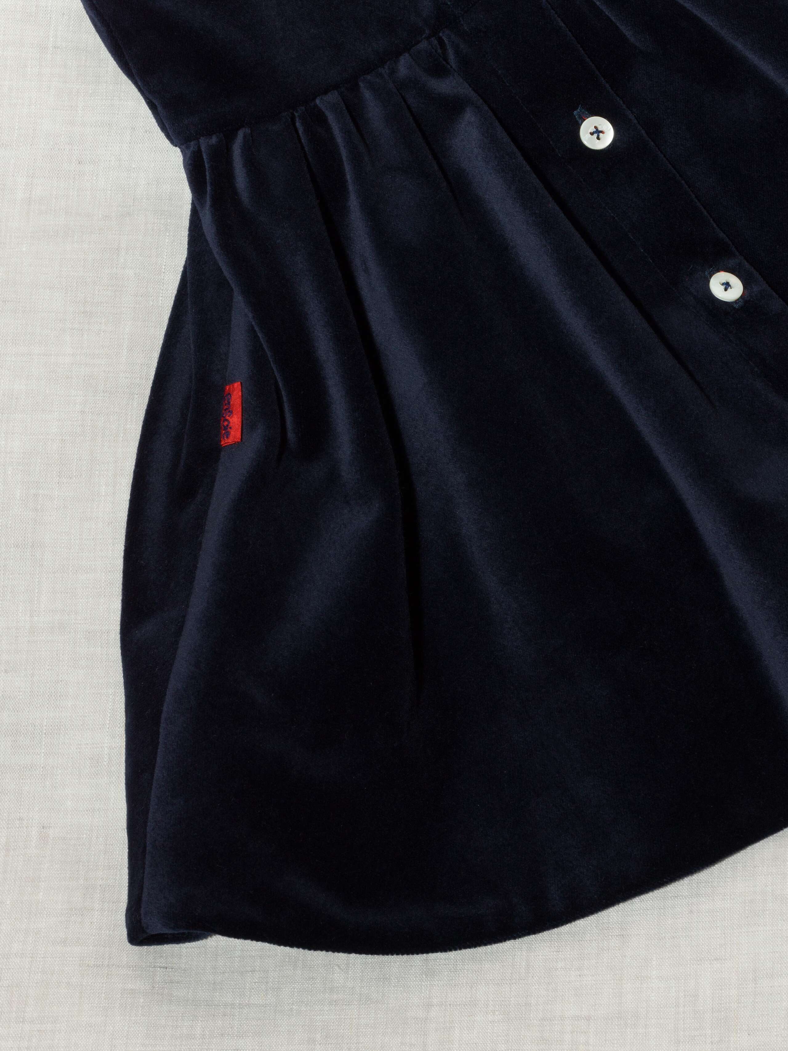 Detail of beautiful cotton velvet baby dress sleeveless with red silk bow handmade in Zurich, navy cotton velvet