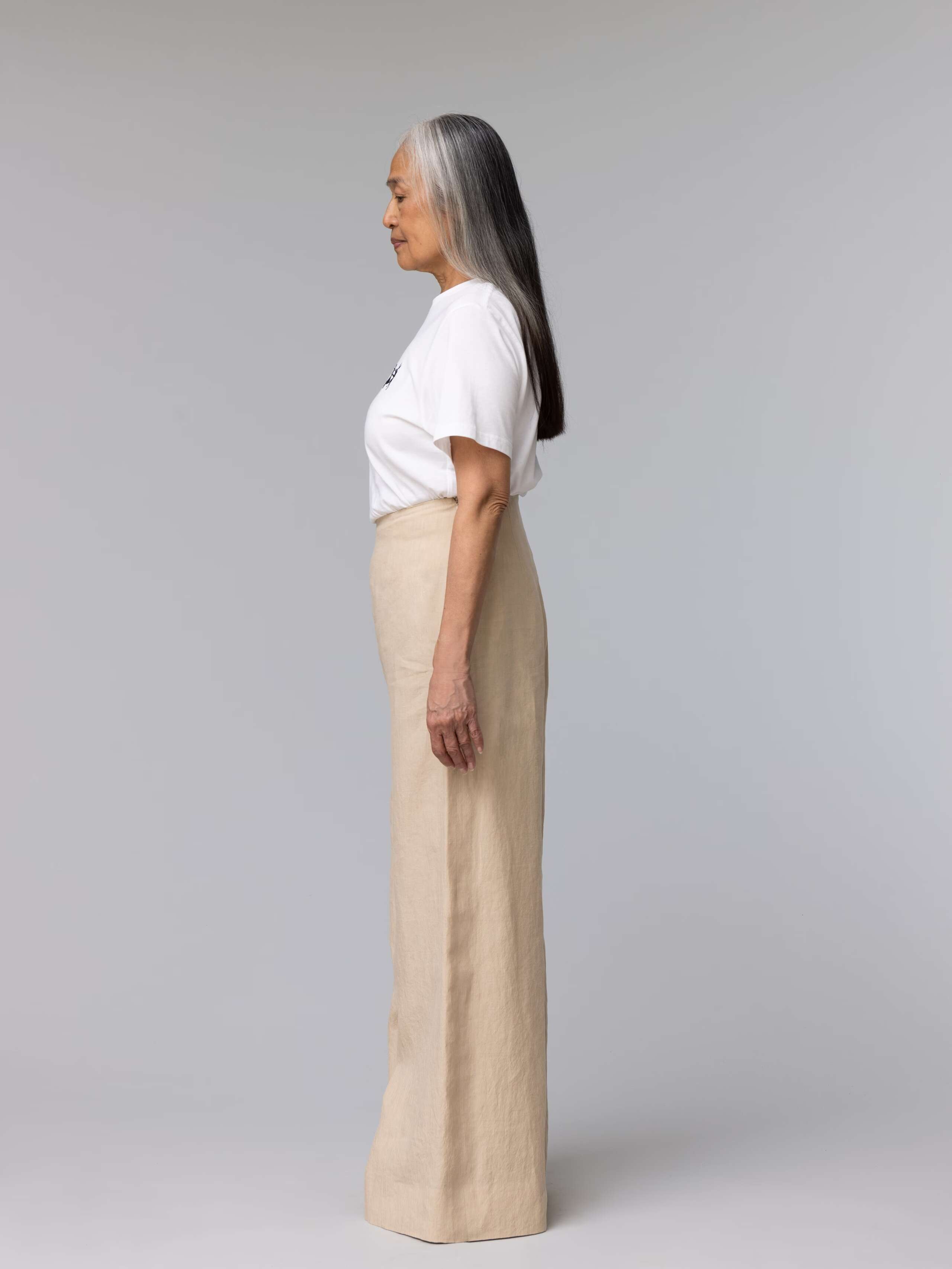 Elderly model is wearing beautiful beige linen trousers