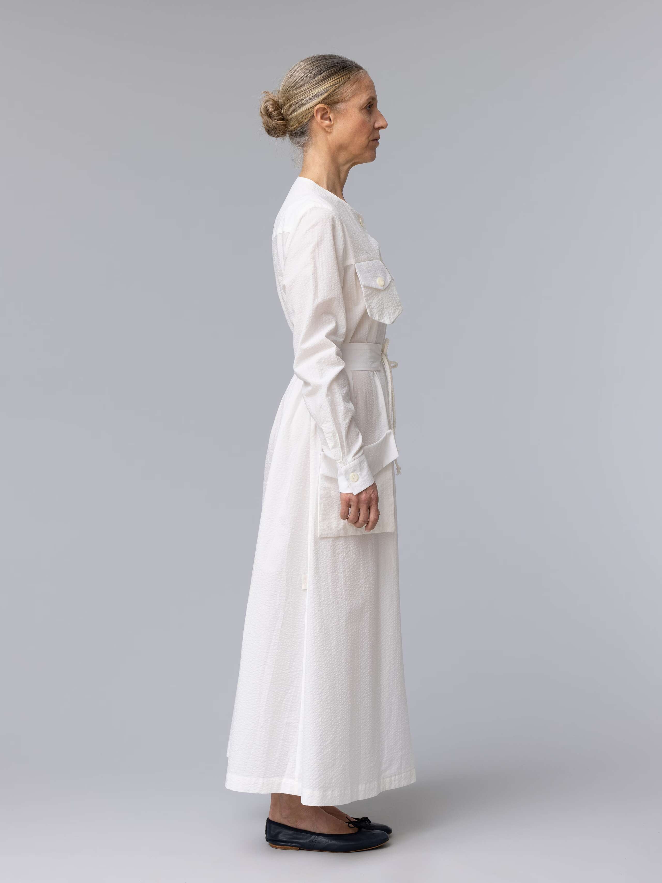 Model is wearing a long white seersucker summer dress 
