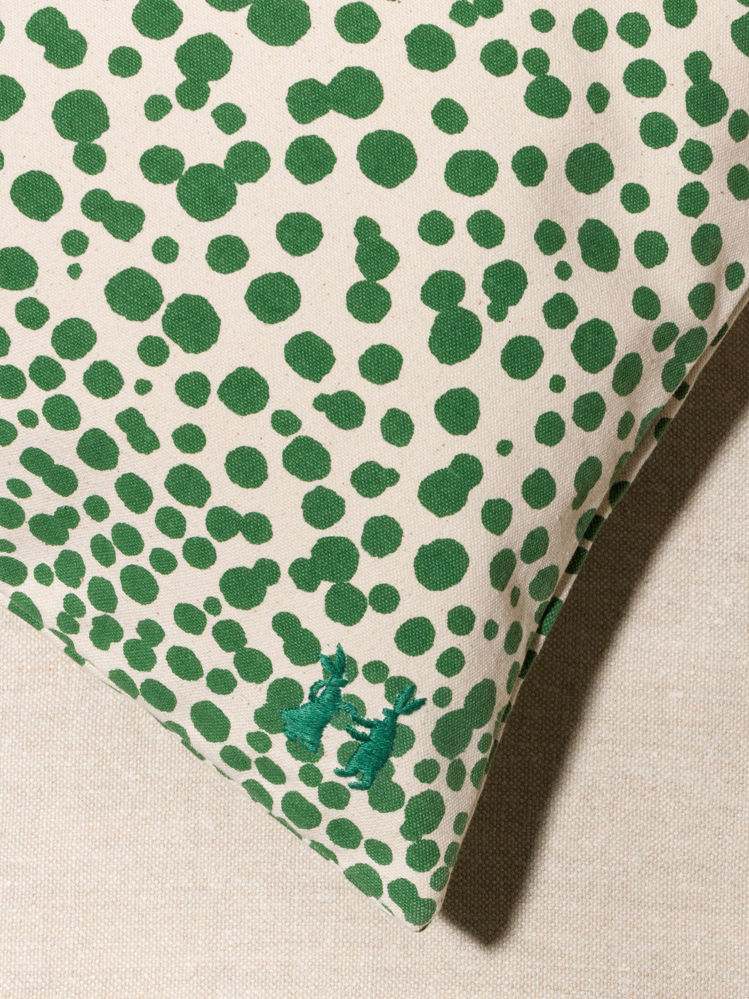 Picture of a detail of a pillow cover made from cotton canvas featuring green dots