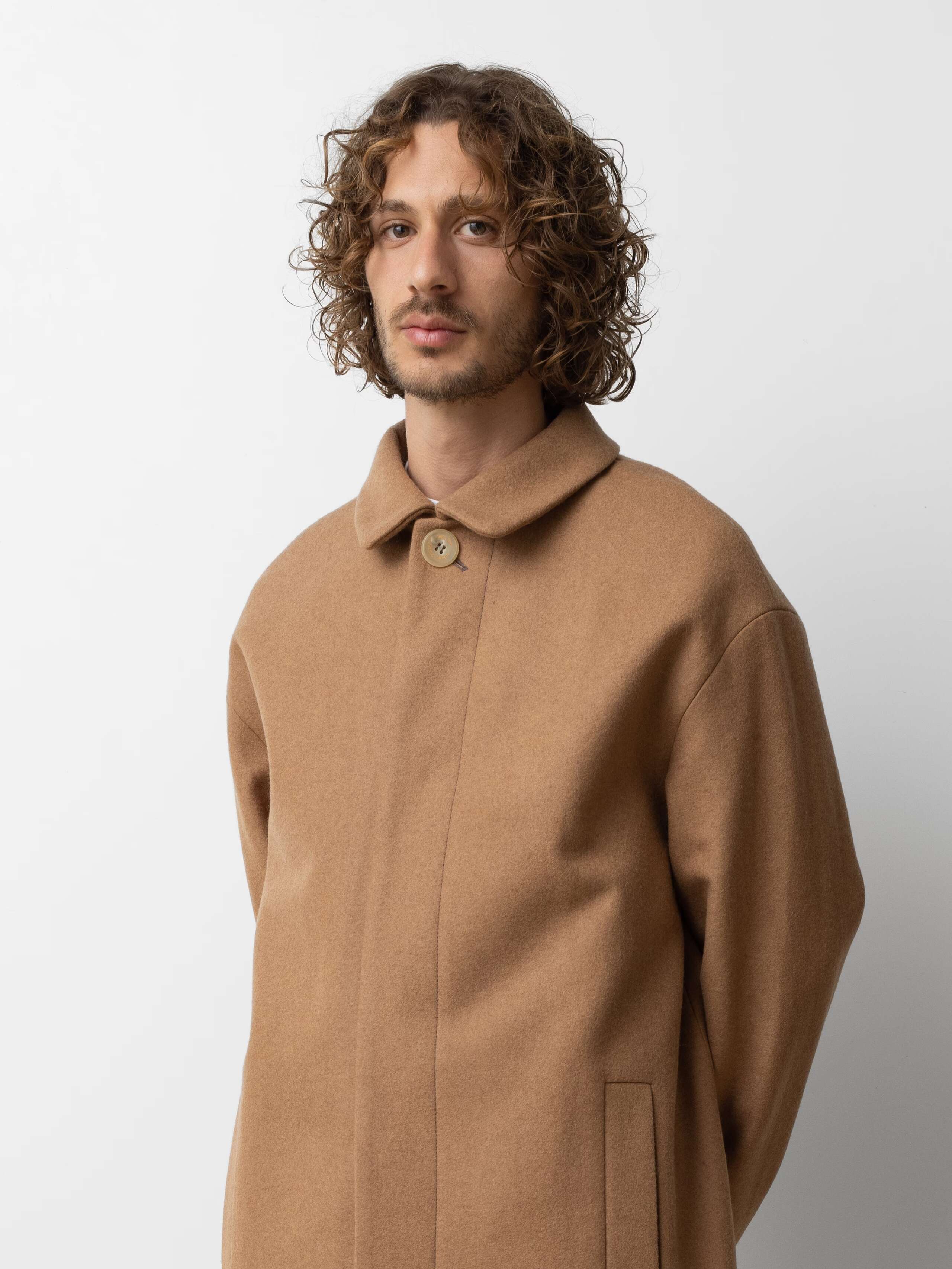Picture of a male model wearing a beige winter coat