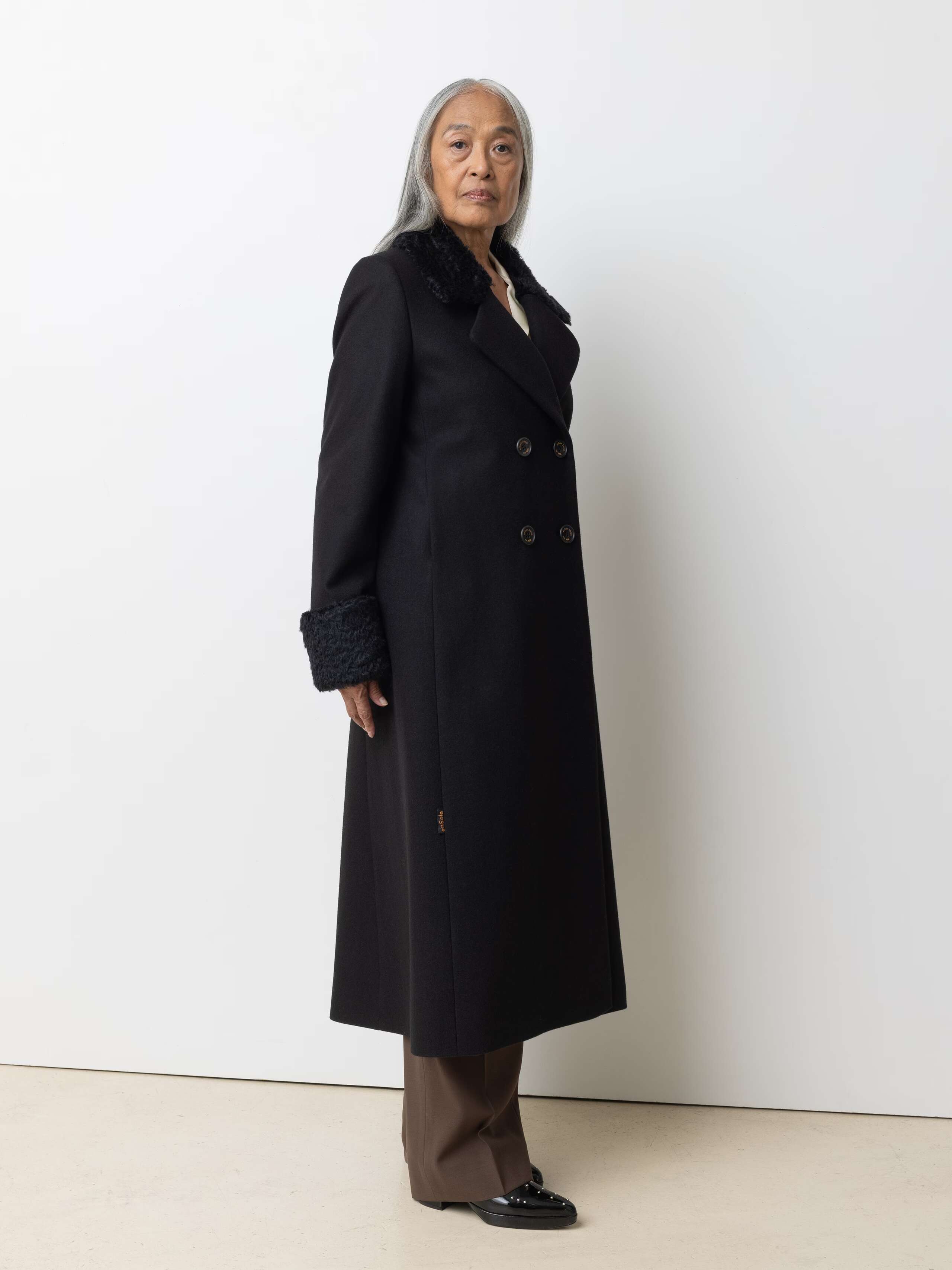 Picture of a female model wearing a black wool coat