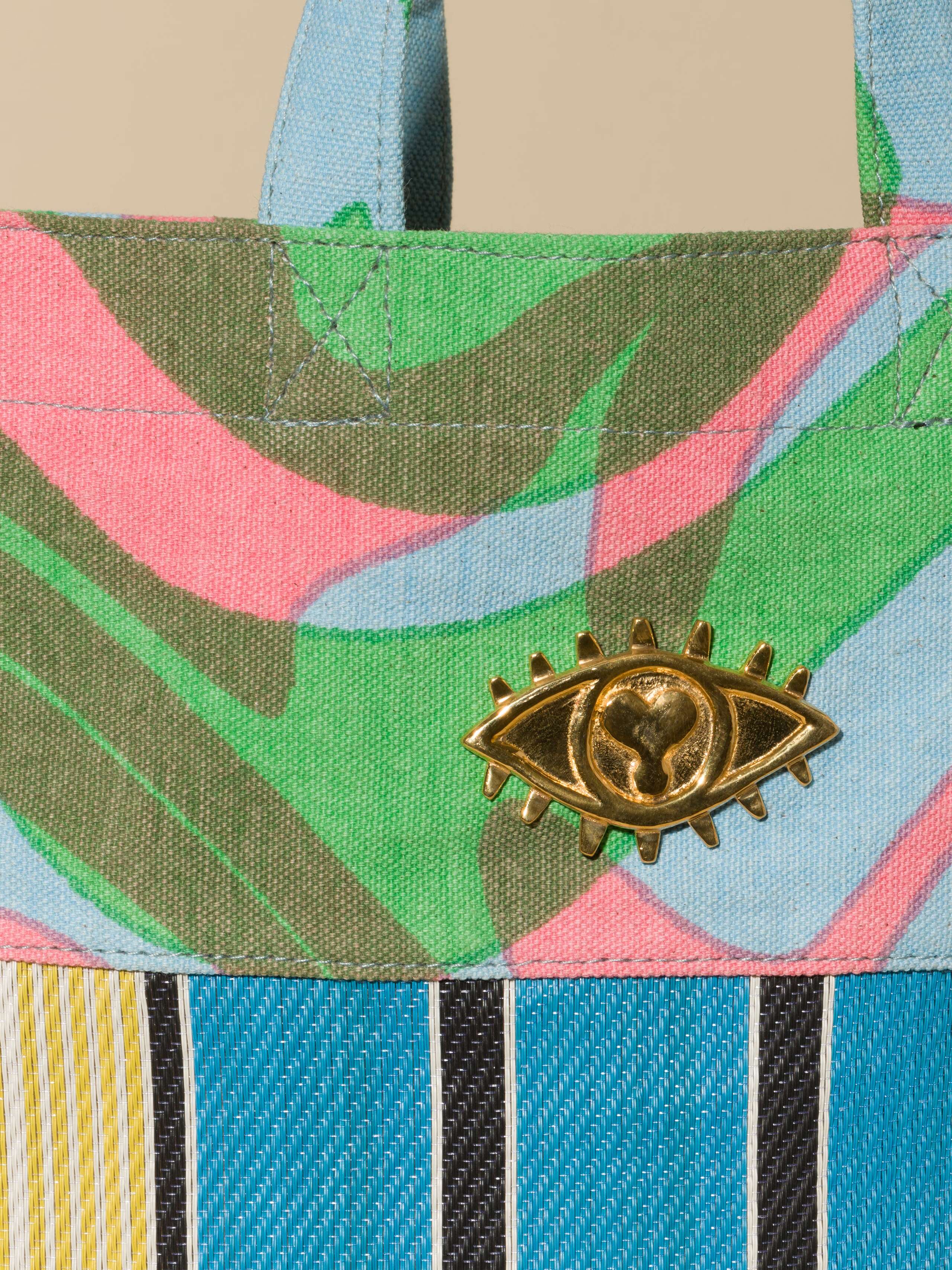 Picture of the Elgin Road bag in blue green and pink colours with a blue and yellow base and a brass detail