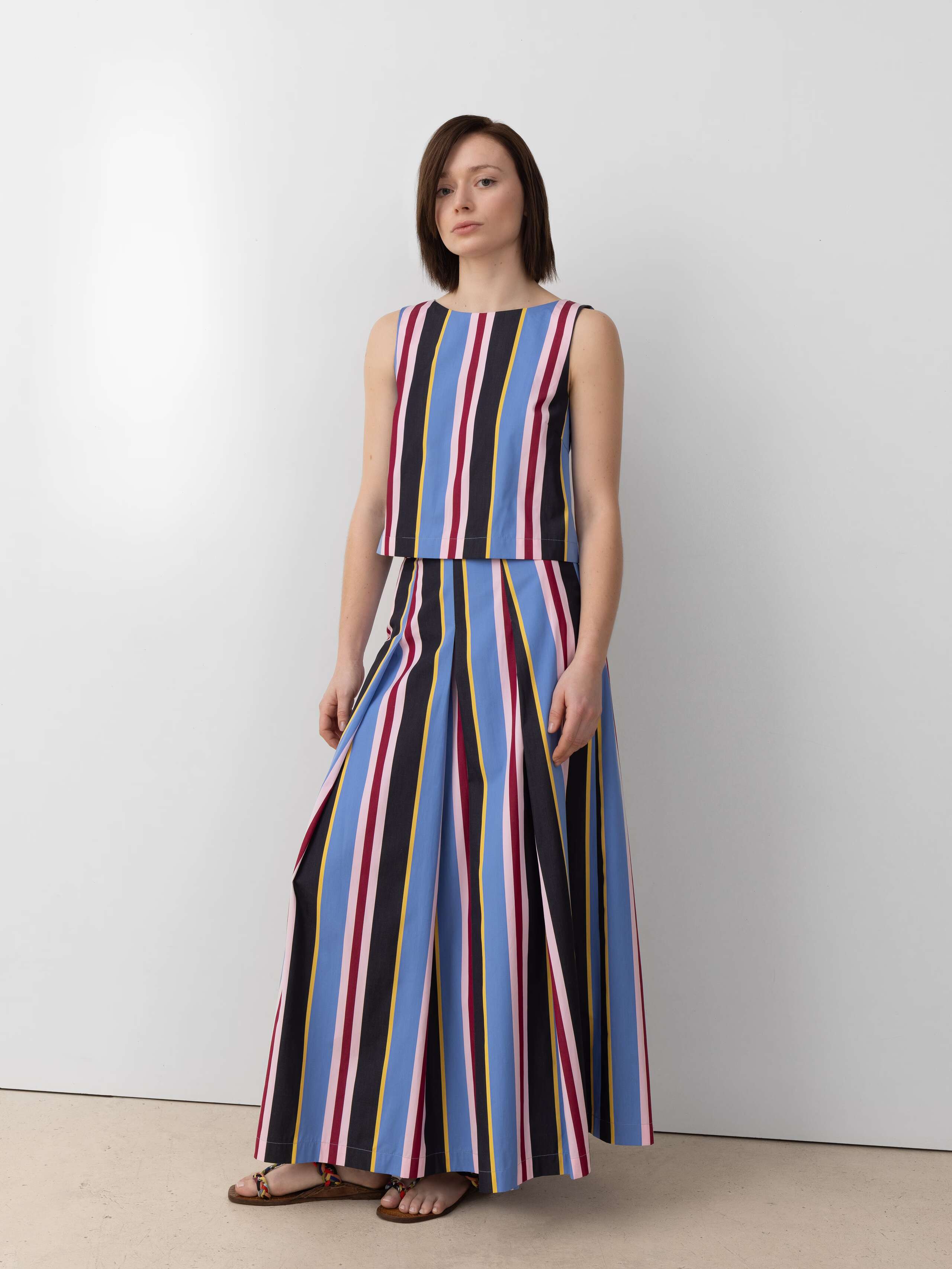 Model wearing Amalia cool down stripe skirt in blue and yellow and pink stripes