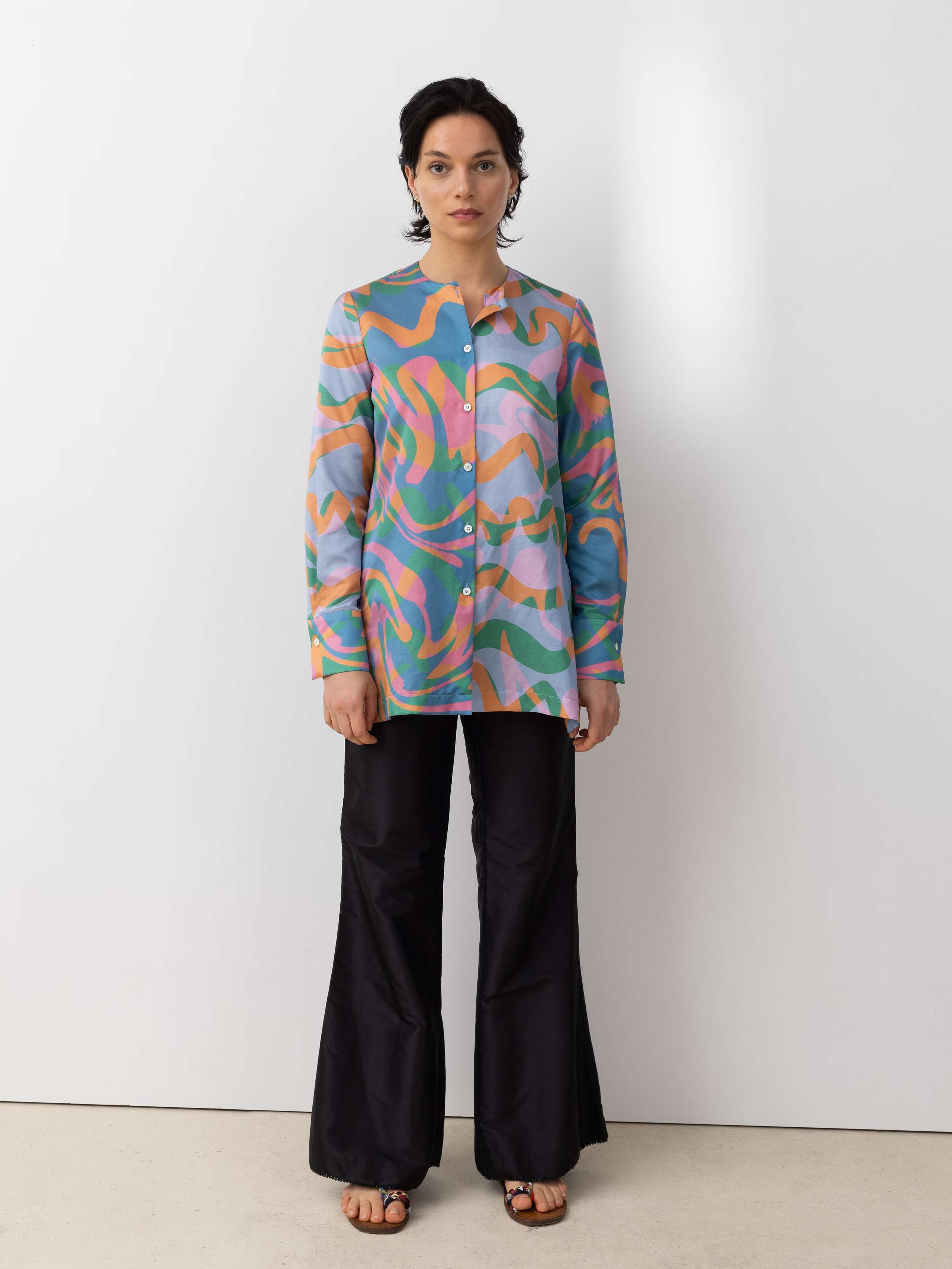 Picture of a model wearing black trousers in combination with a colourful silk clouse