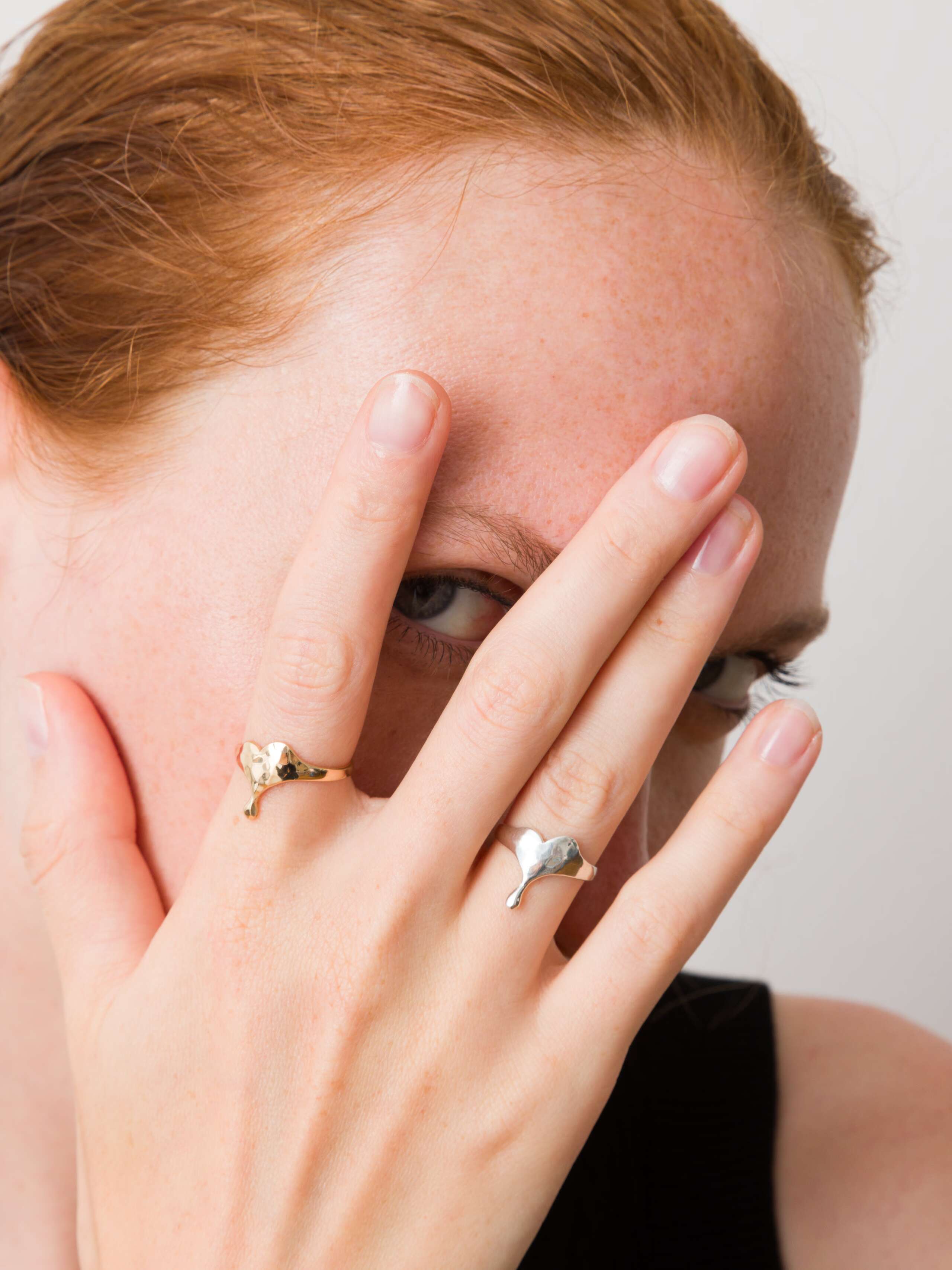 Model wearing soft heart xs rings in gold and silver