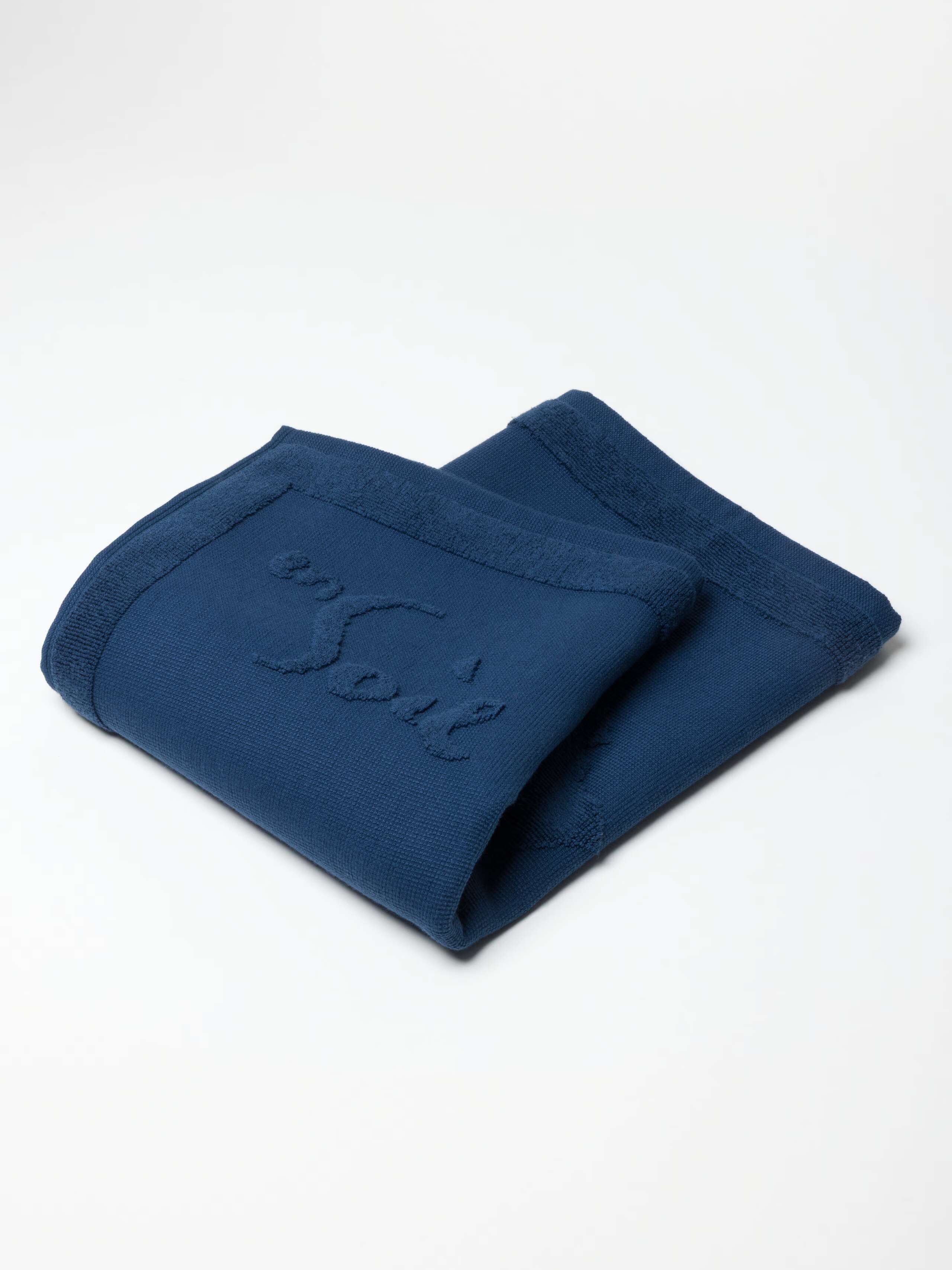 Soft Zurich Navy terry bath mat with rabbits and logo