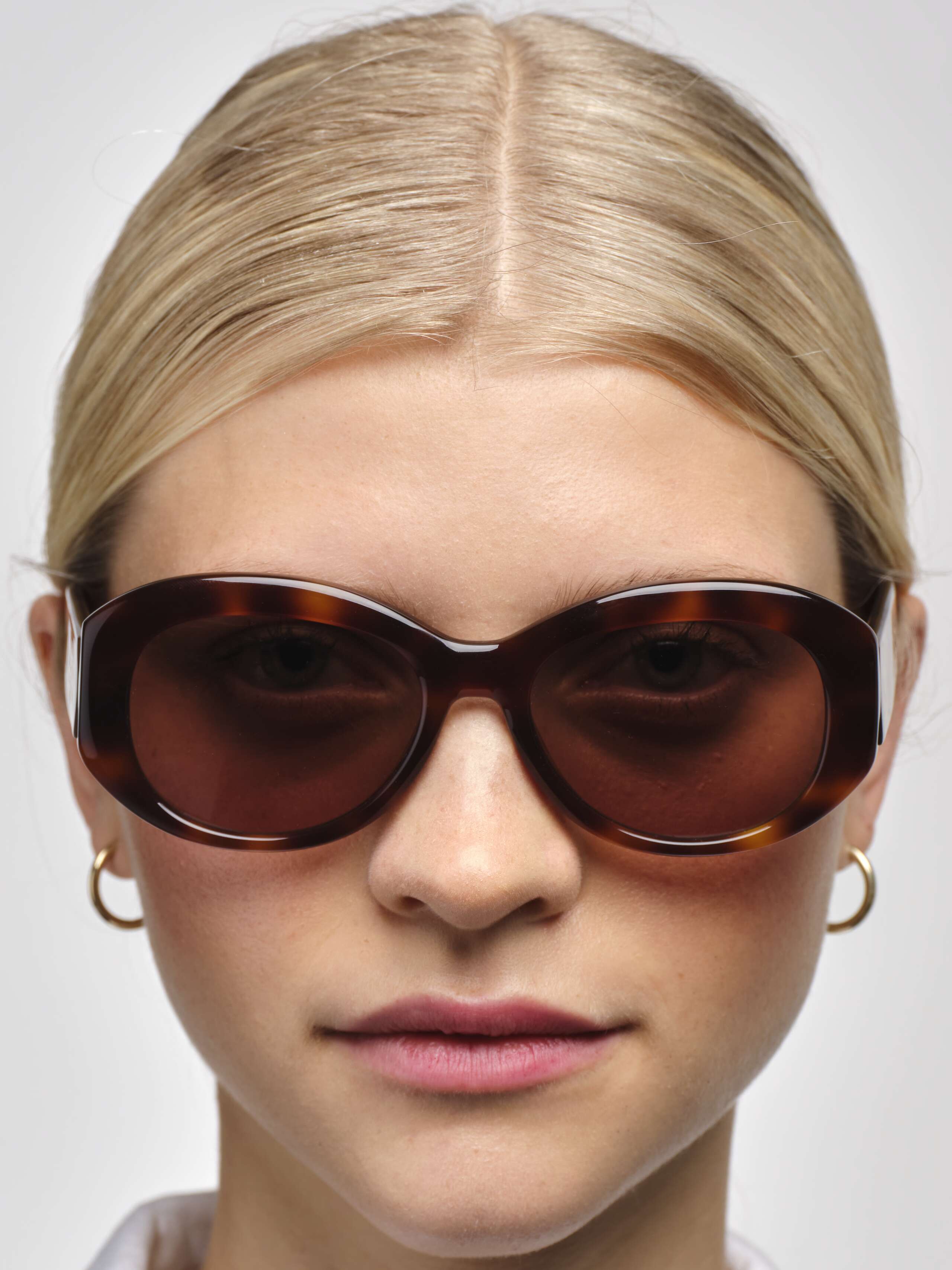 USE: closeup front detail shot of model wearing tortoise brown capri sunglasses 