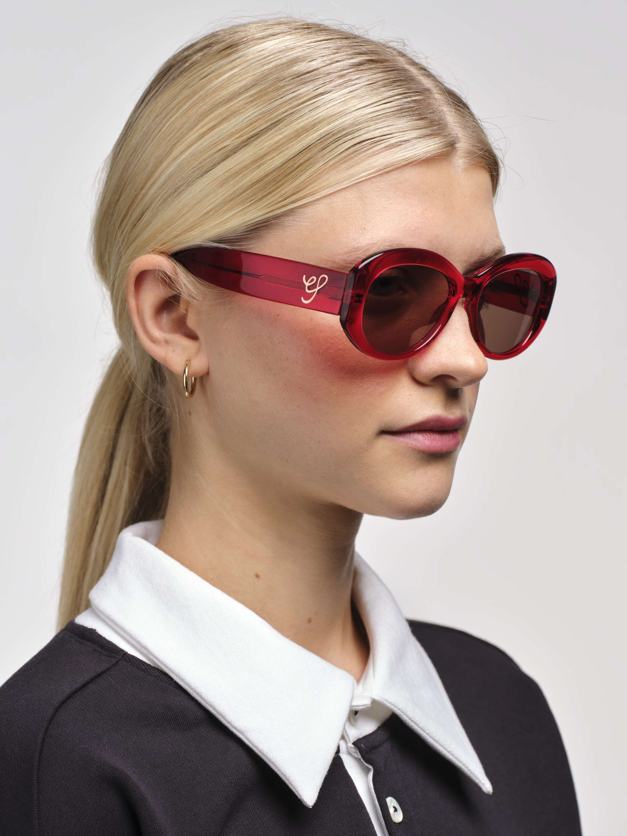 Side shot of Model wearing Capri Sunglasses in Red showing gold ES Logo 