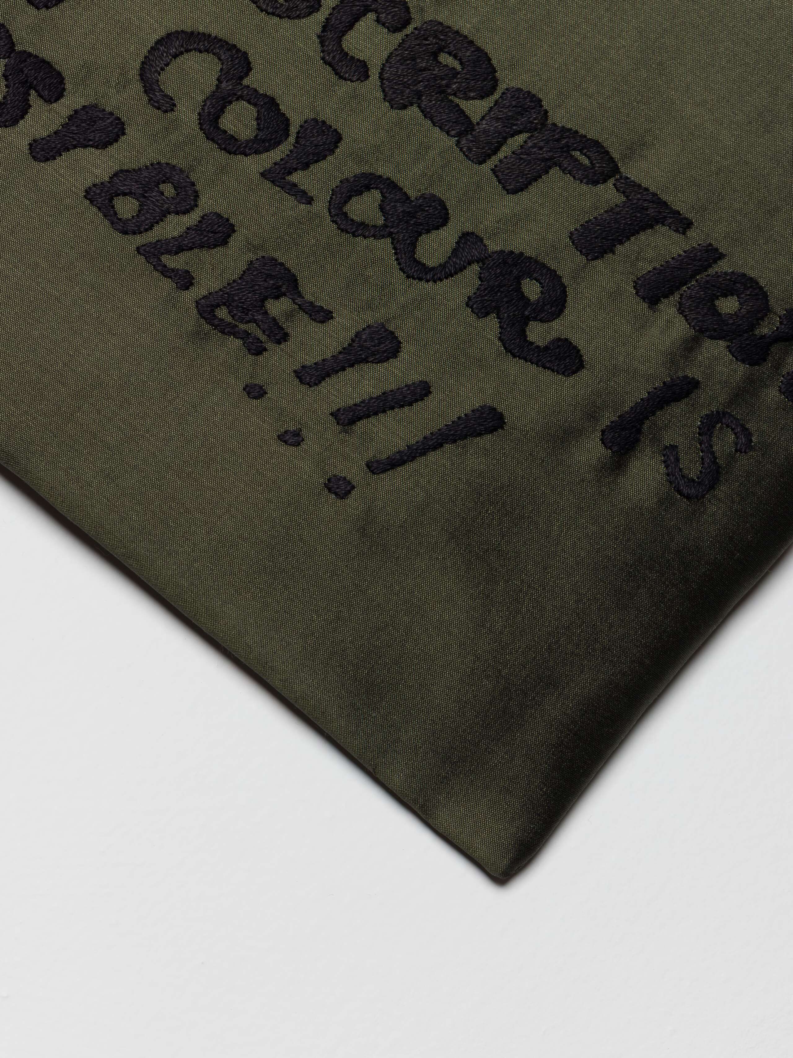 Detail shot of Proverb Clutch in Khaki Green on the description of color side 