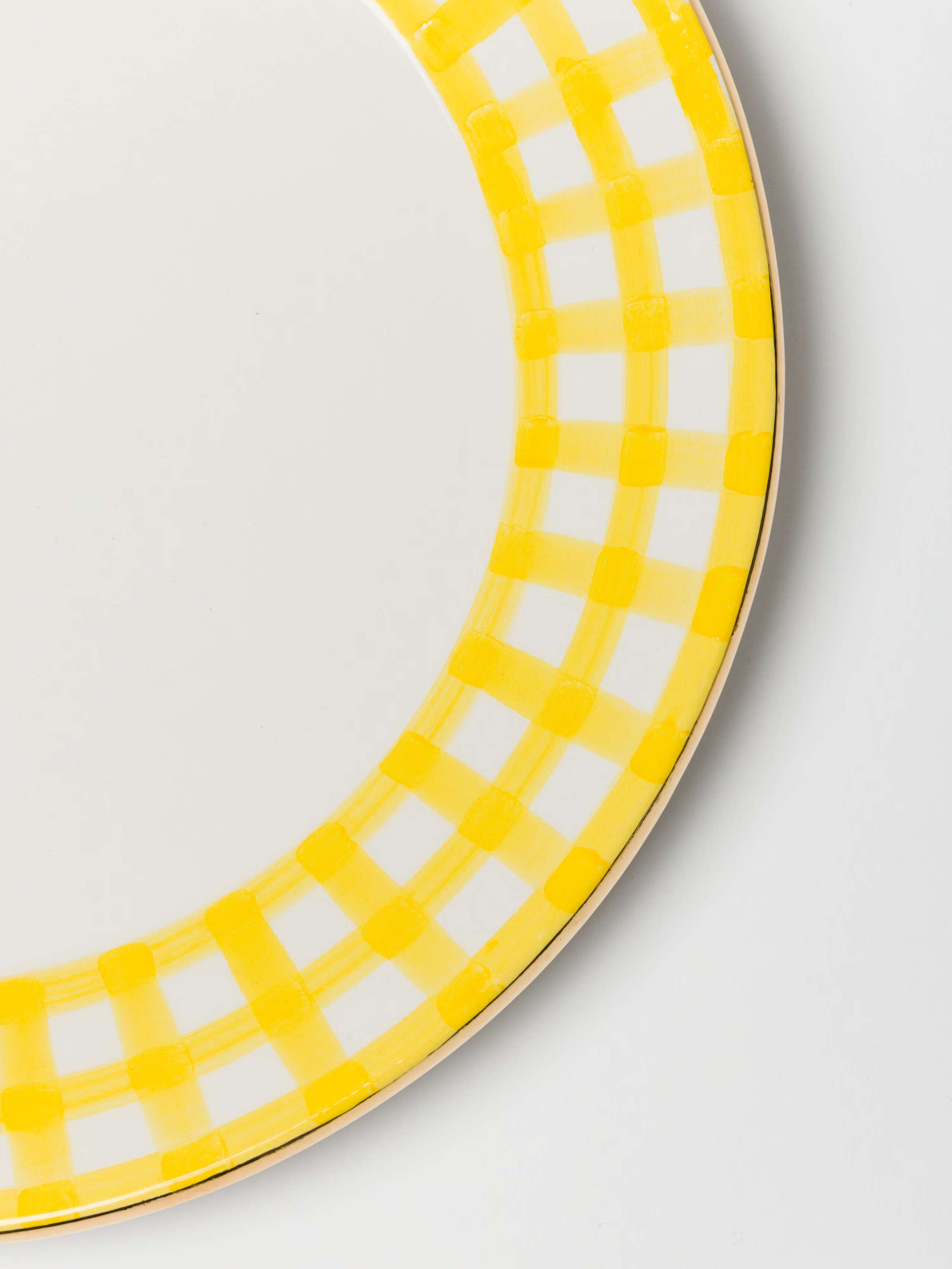detail shot of gold rim on plate in sunny yellow 