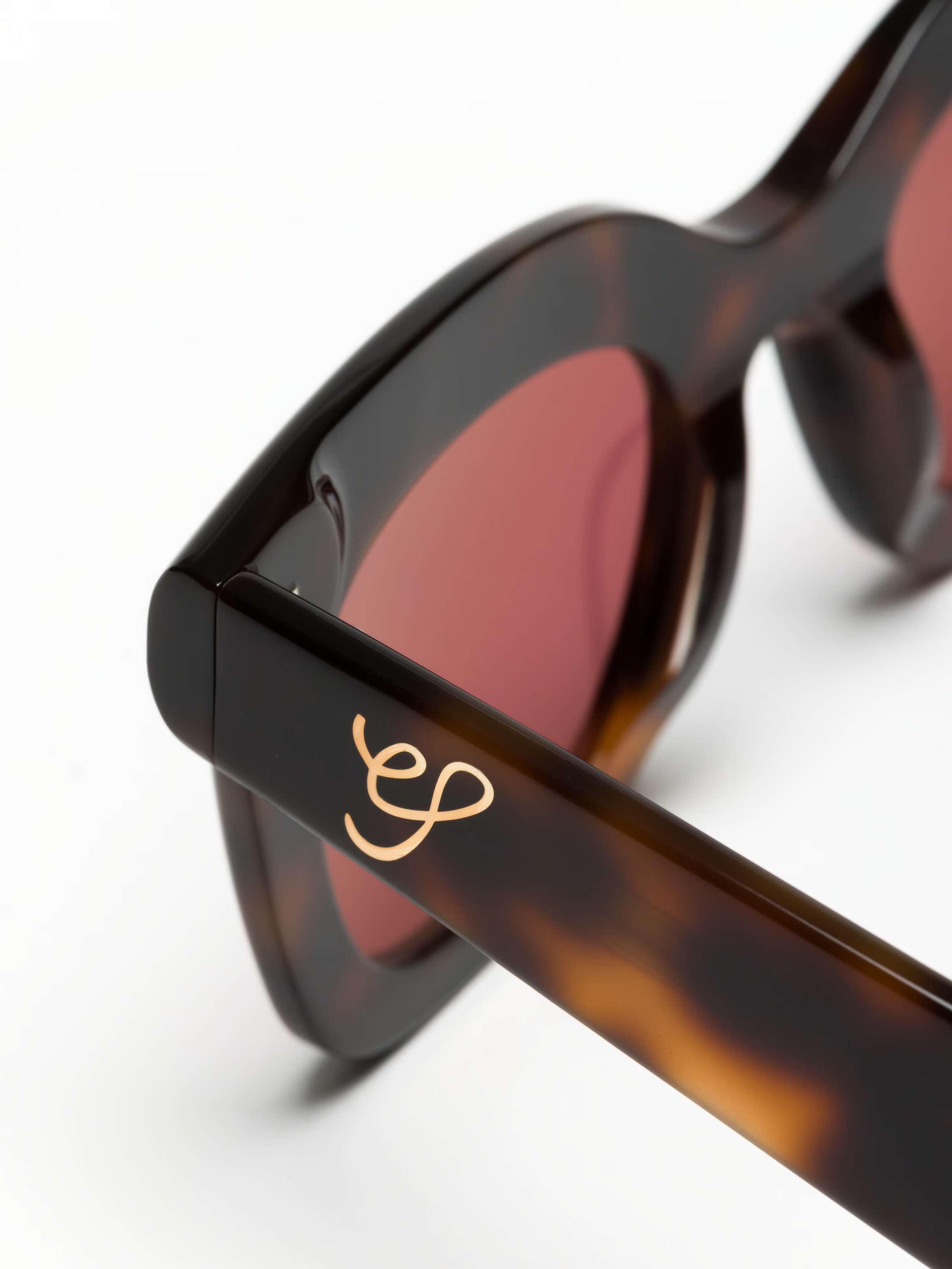 Detail  Shot of gold ES logo on Toni Sunglasses in Tortoise w Red Lenses  
