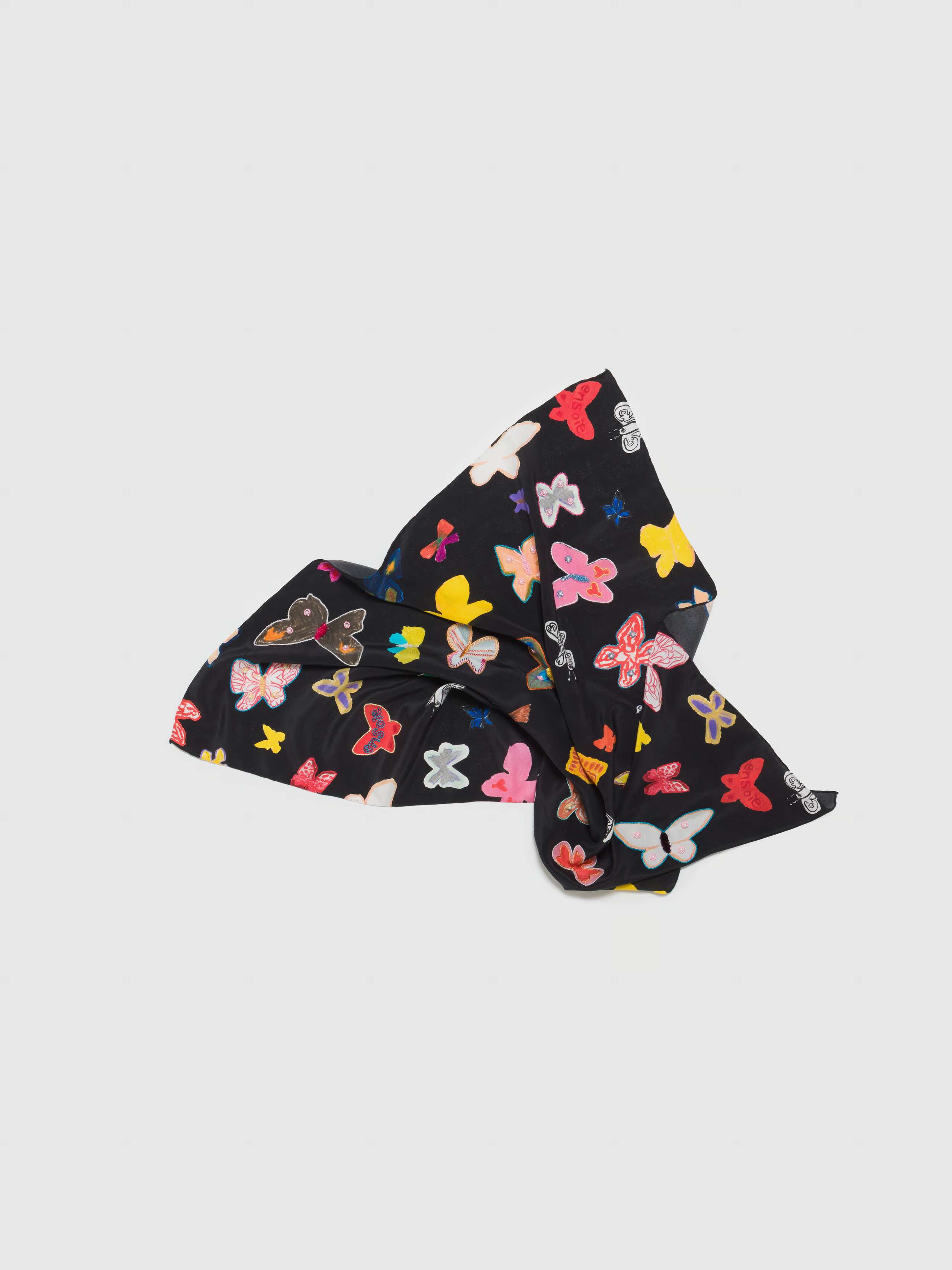 Product shot of Carre Foulard butterfly print casually laid out