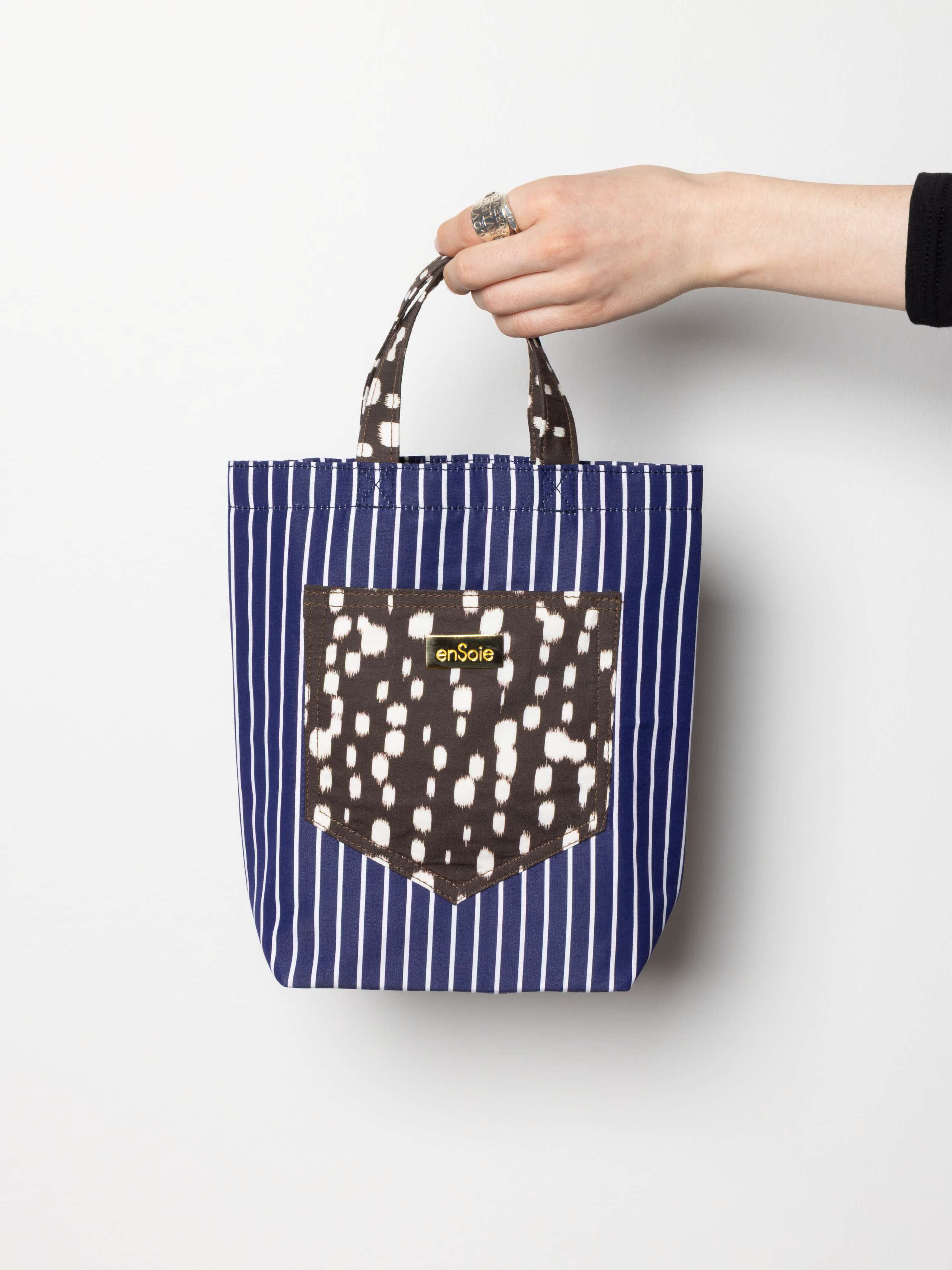 Product shot of June Bag in Navy Stripe with Bambi Dot accents in hand 