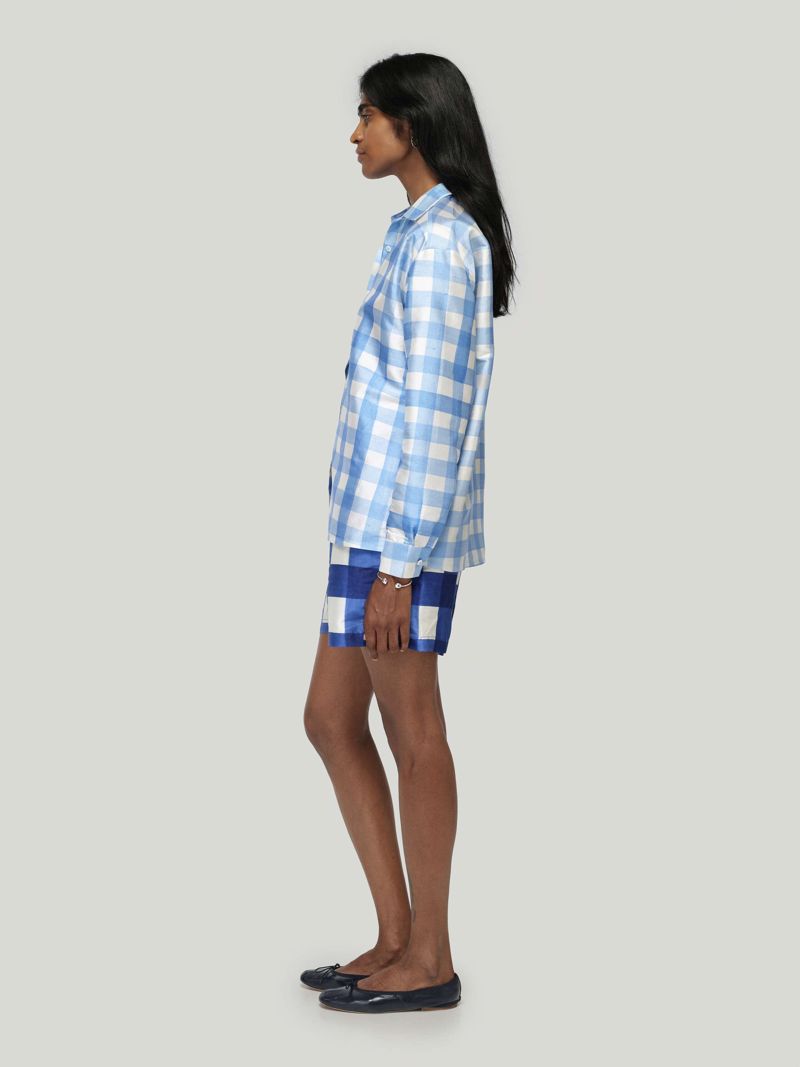Female model wearing Francesca blouse in ocean blue paired with allen shorts in zurich navy