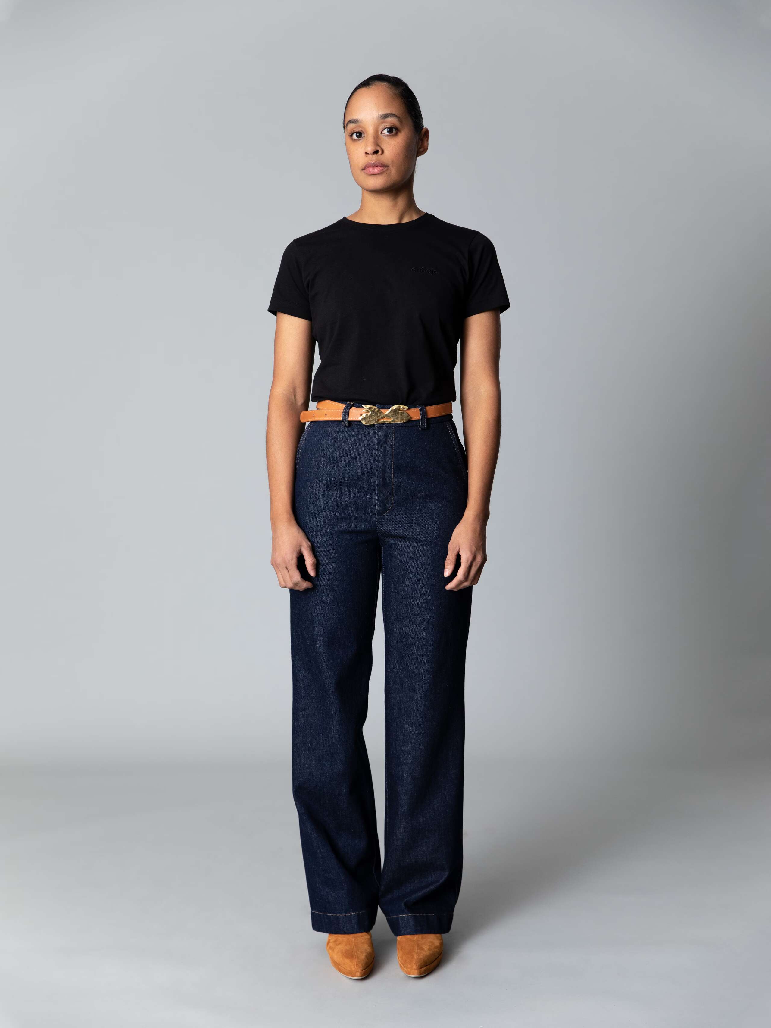 Model is weraing a cotton denim wide leg jeans in a classy indigo colour combined with a white shirt and black ballerina flats 