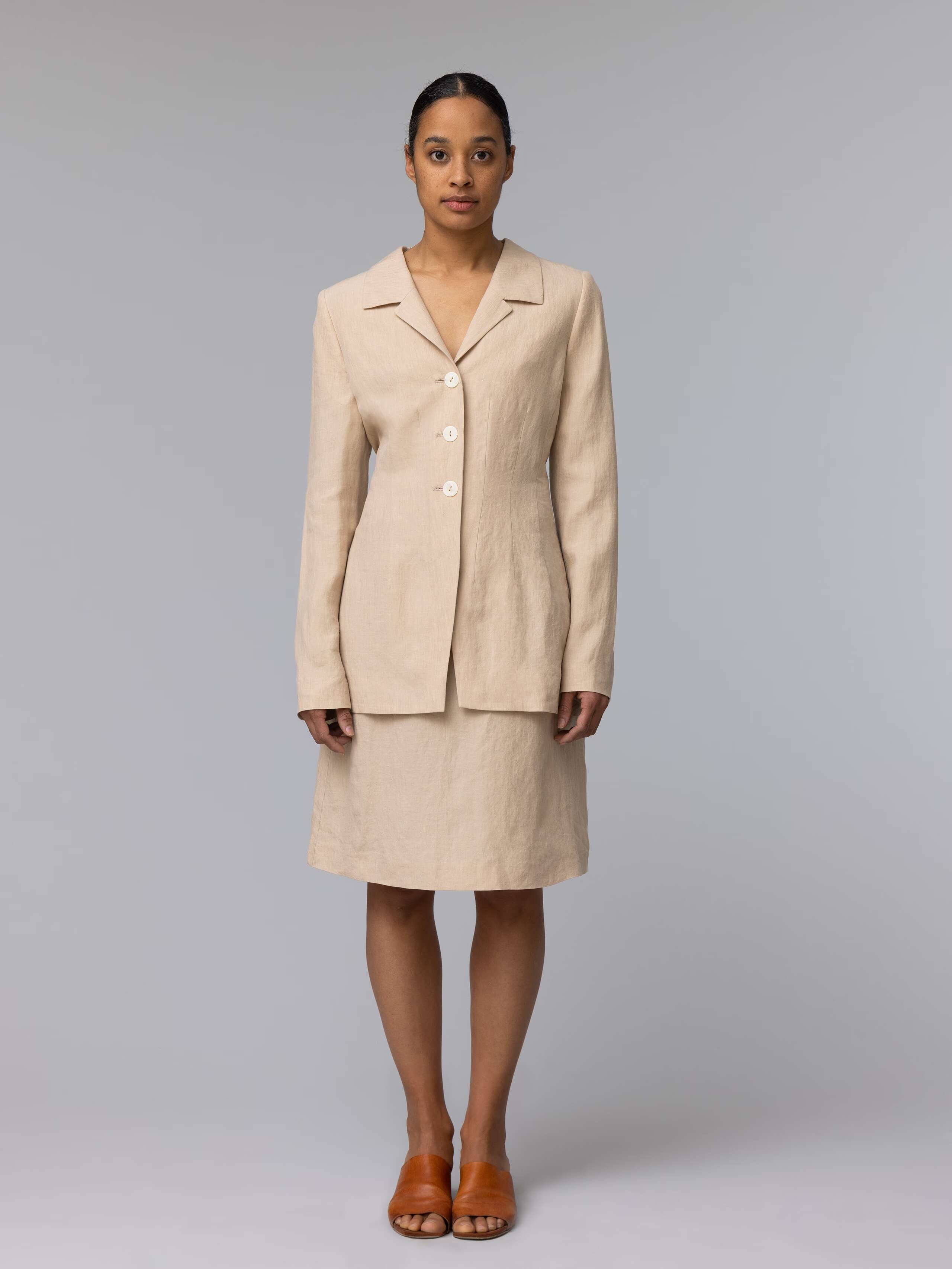 Model is wearing a nice combination of a beige linen blazer and a beige linen skirt