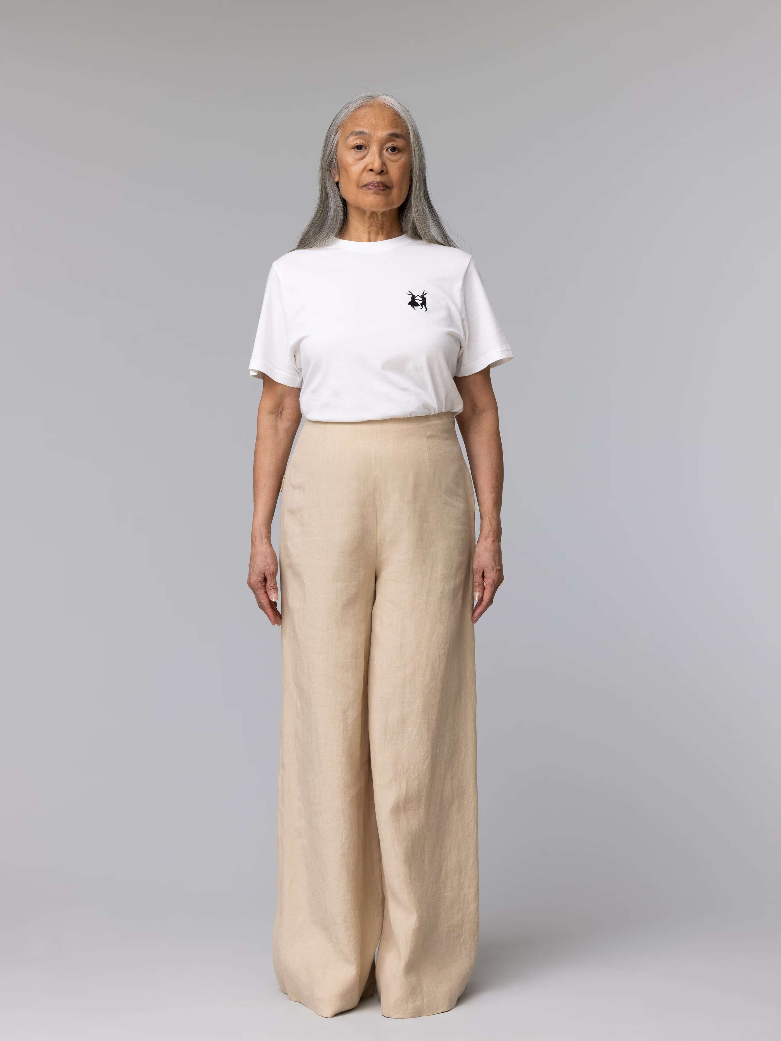 Elderly model is wearing beautiful beige linen trousers