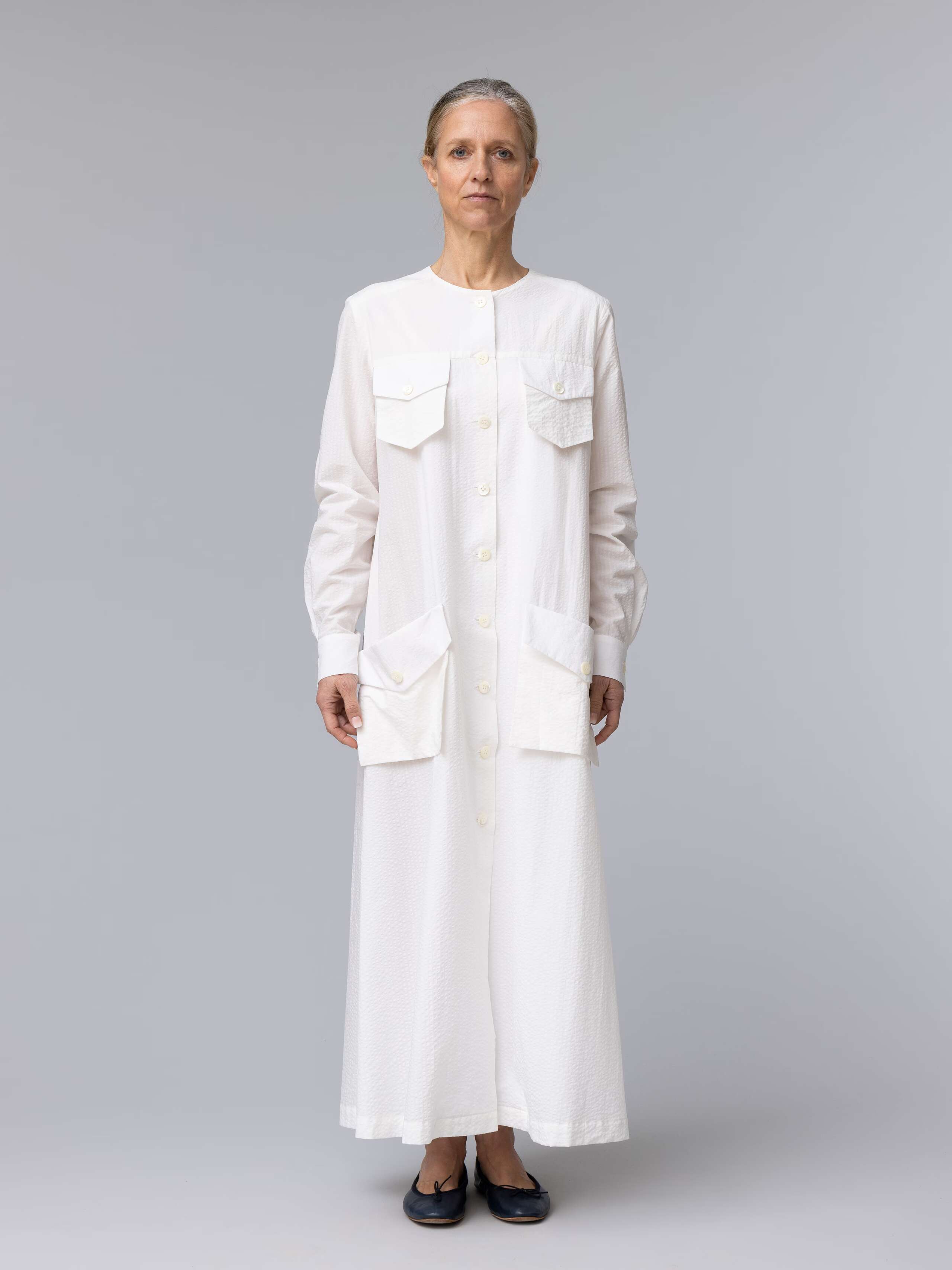 Model is wearing a long white seersucker summer dress 