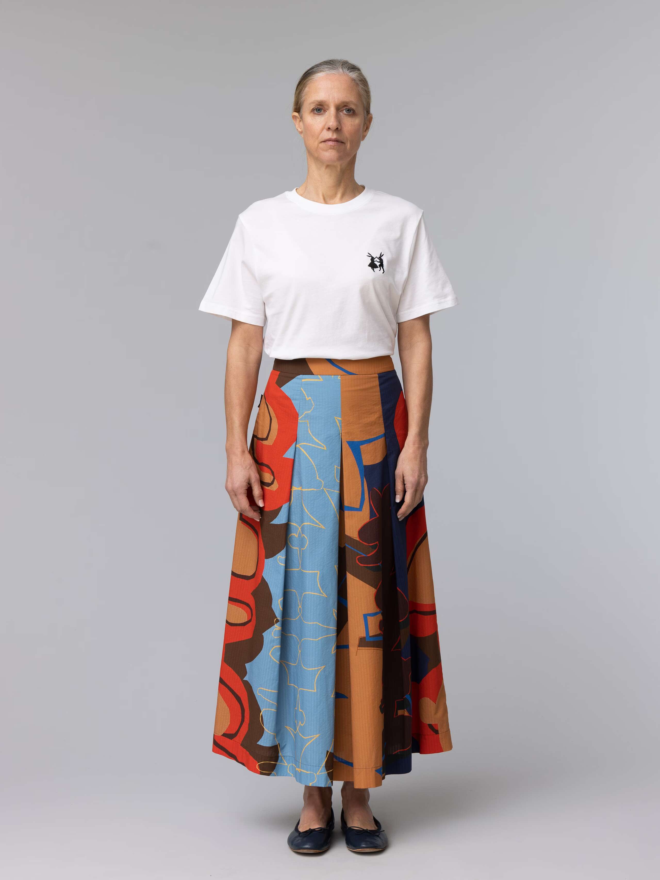 Model is wearing a colourful skirt in brown and blue shades