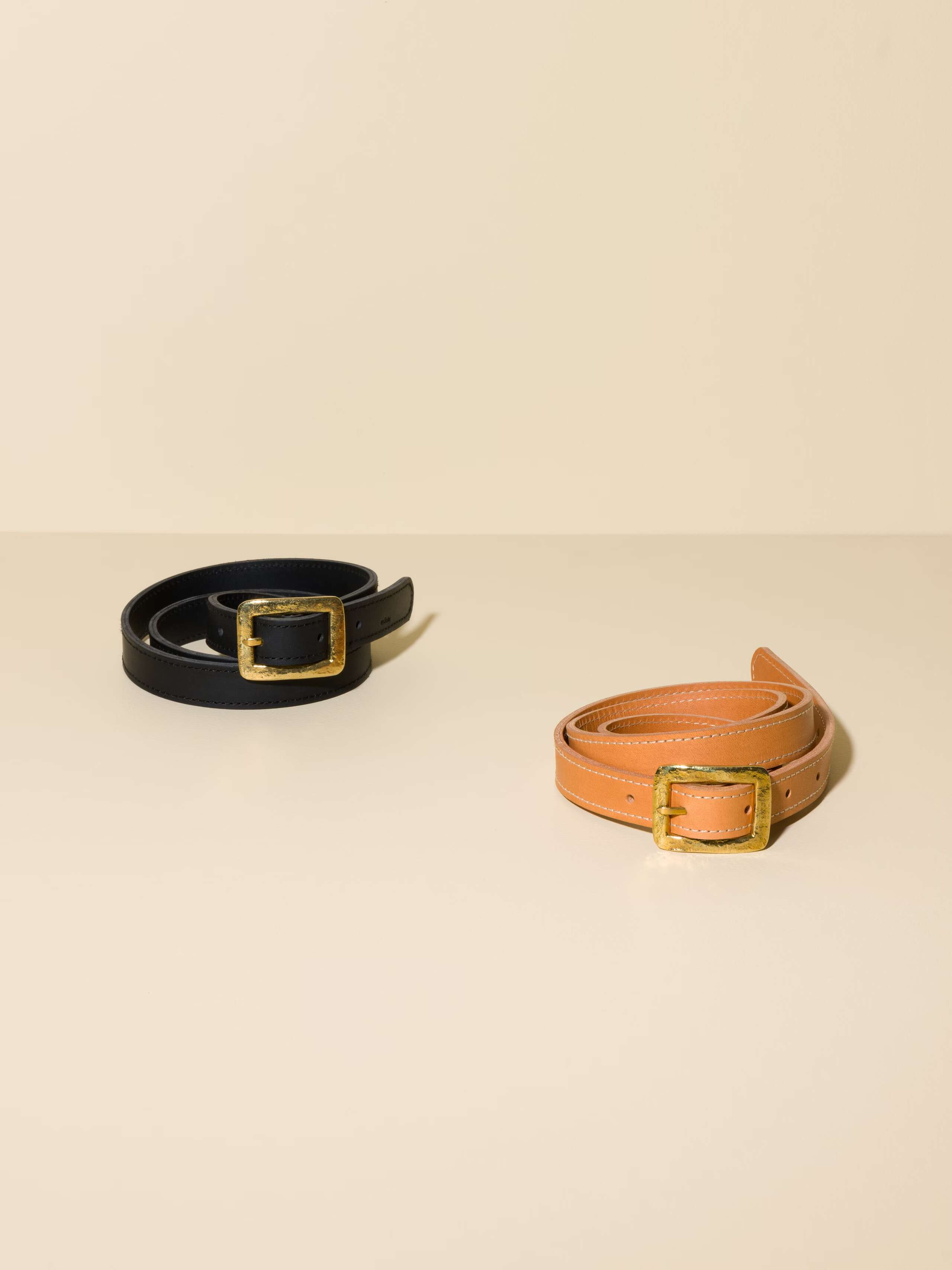 Picture if two leather belts in black and cognac 