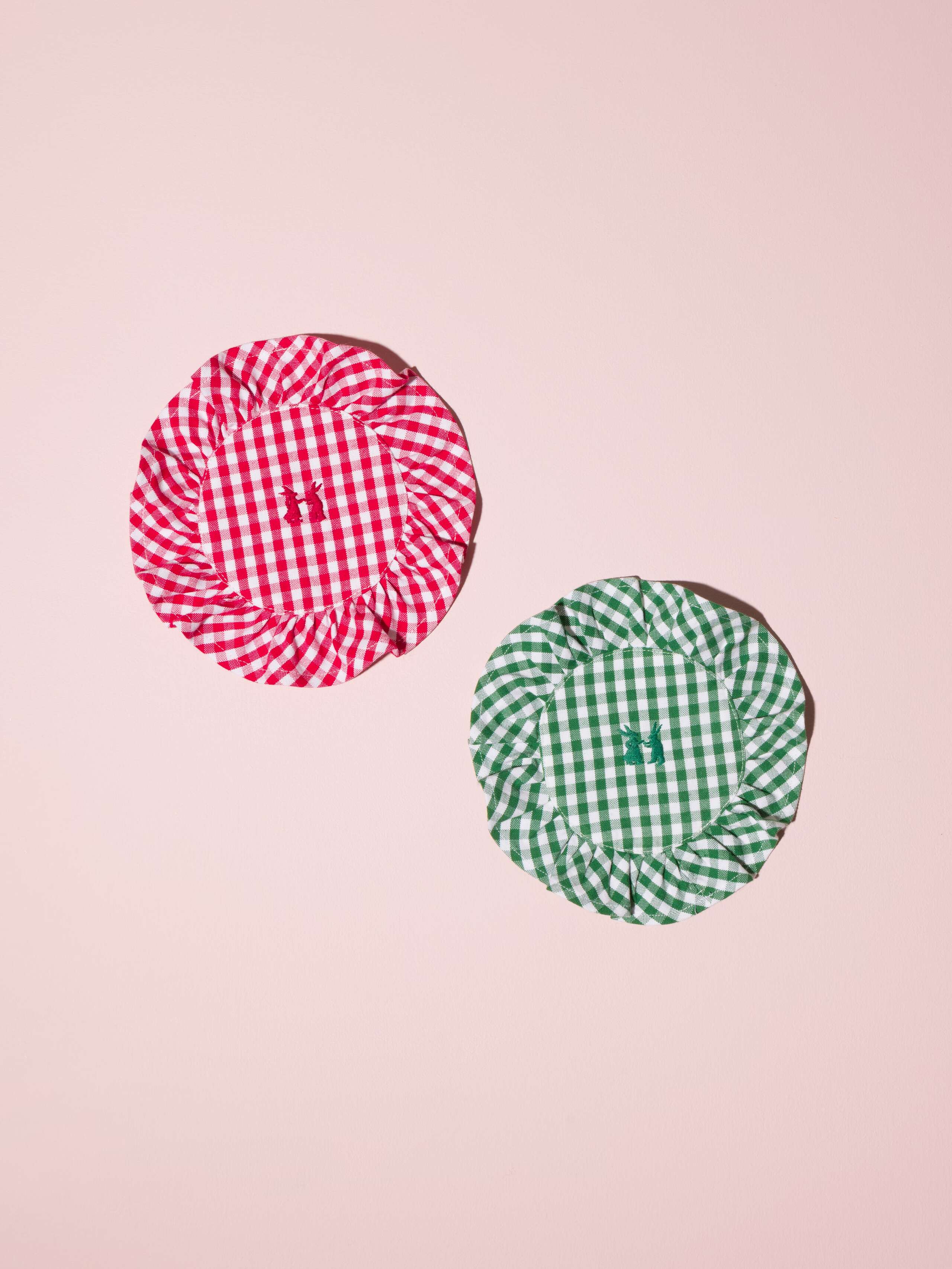 Picture of two beautiful cotton coasters in green and red featuring a ruffled edge