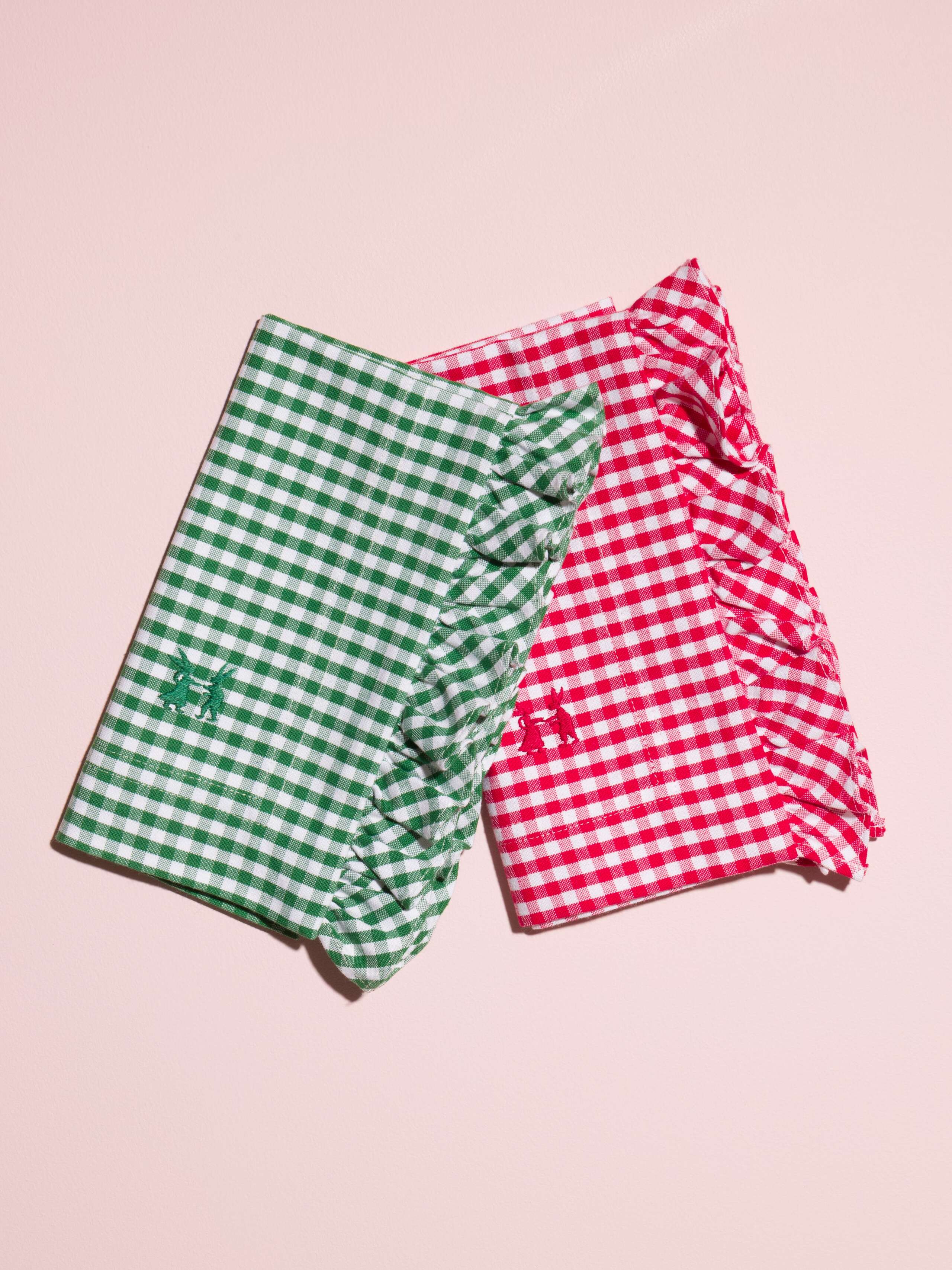 Picture of two napkins in green and red featuring a check pattern and ruffled edge