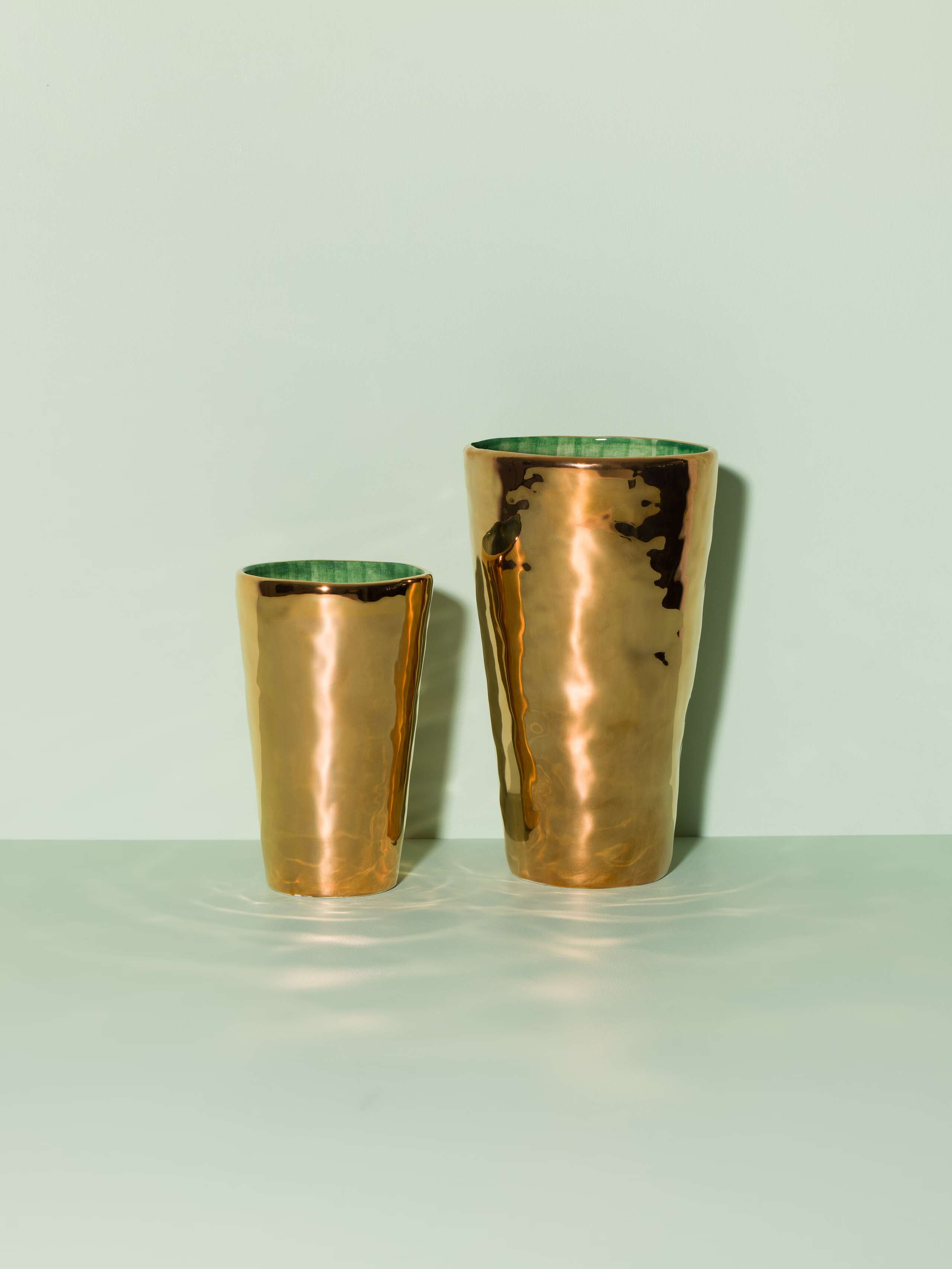 Picture of a two golden vases featuring a green inlay