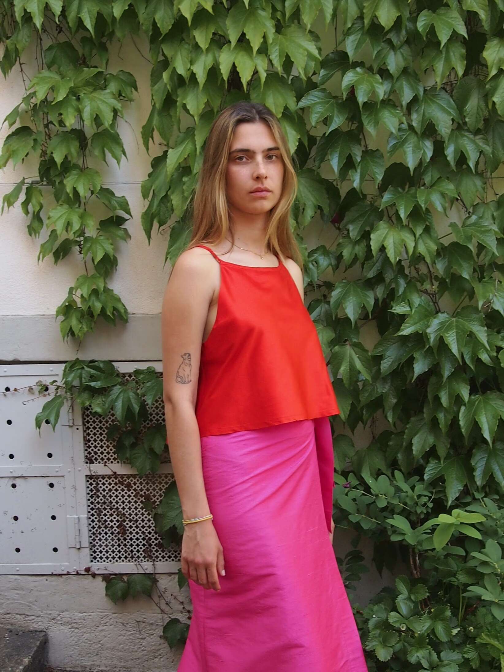 Picture of a model wearing a red top in combination with pink skirt