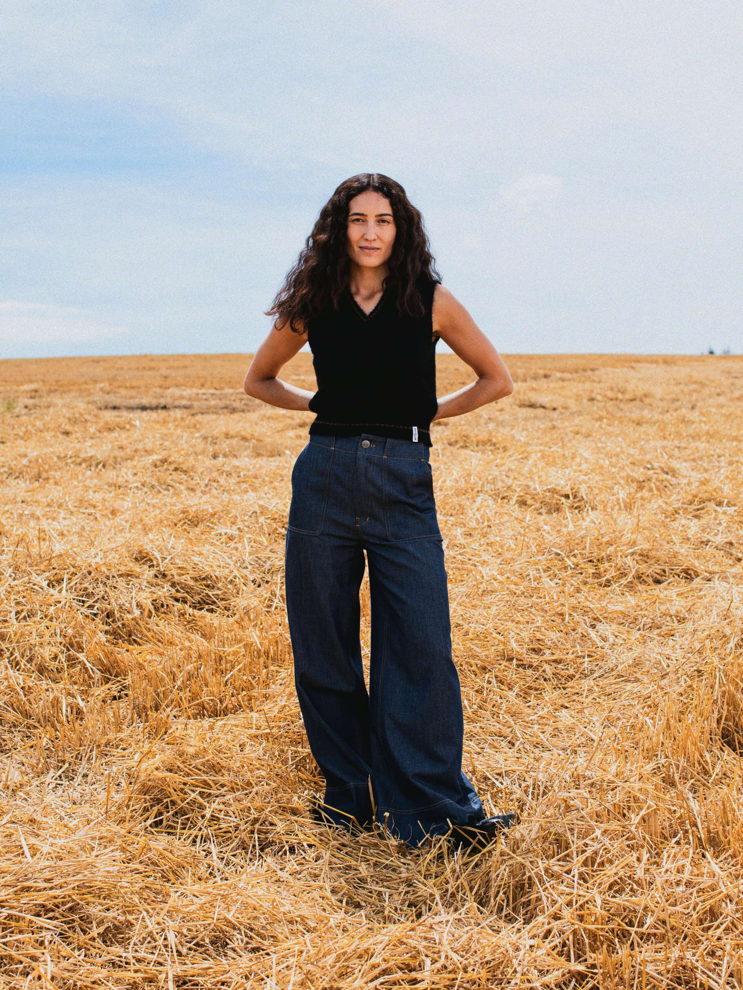 Picture of a female model wearing a black cashmere top in combination with a jeans