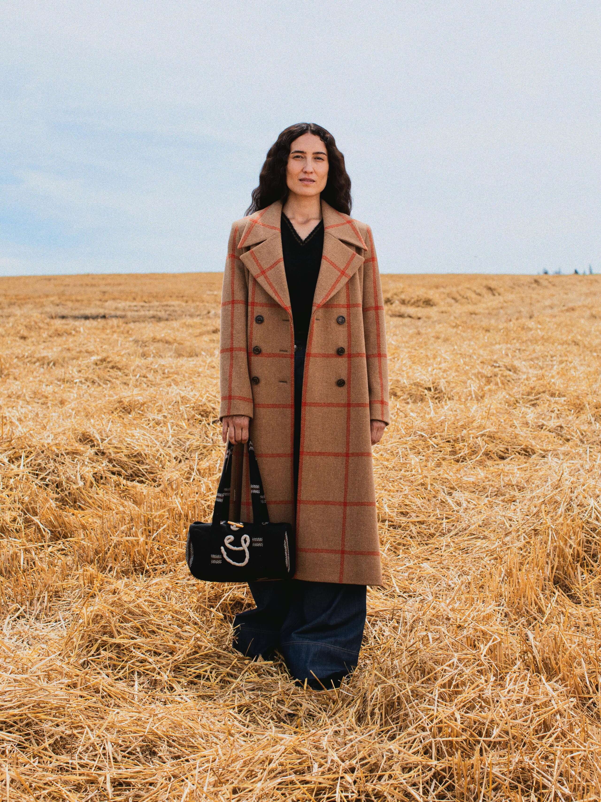 Picture of a female model wearing a beige Harris tweed coat