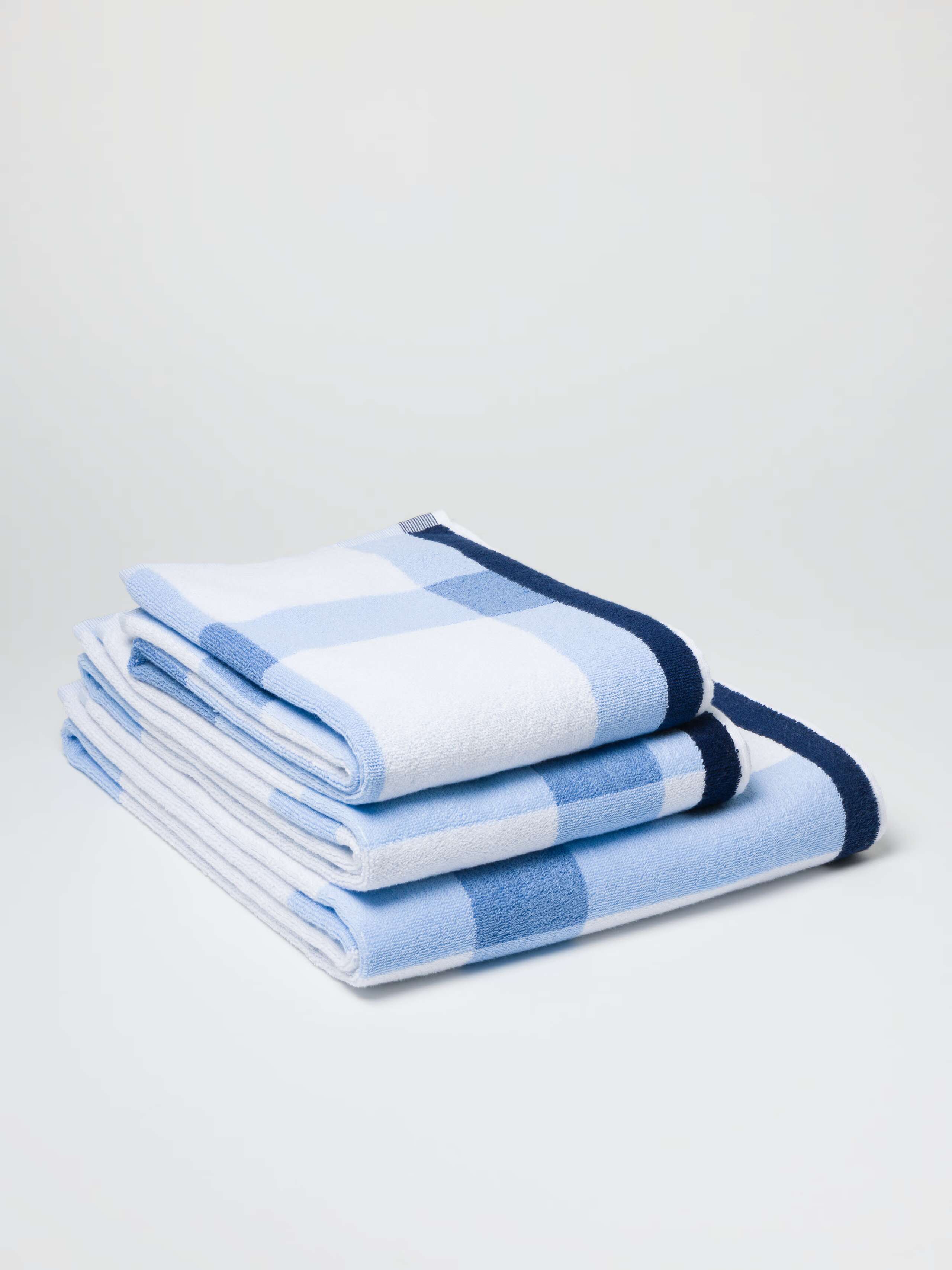 Terry bath towel in light blue vichy check with navy borders in a stack