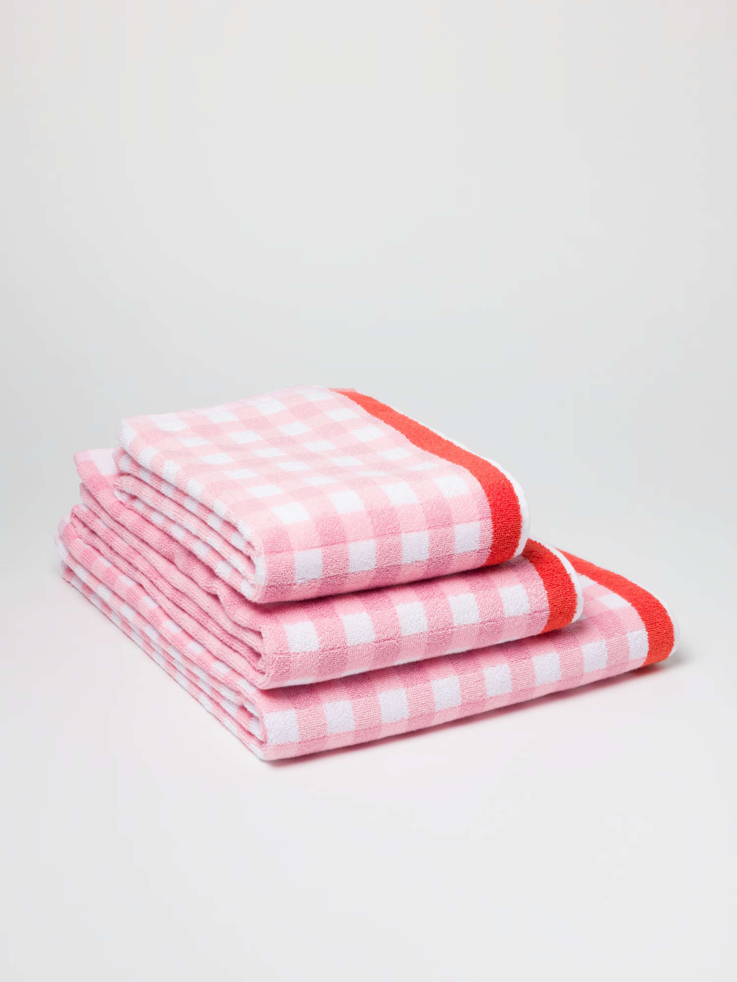 Terry bath towel in Pink vichy check with Red borders in a stack