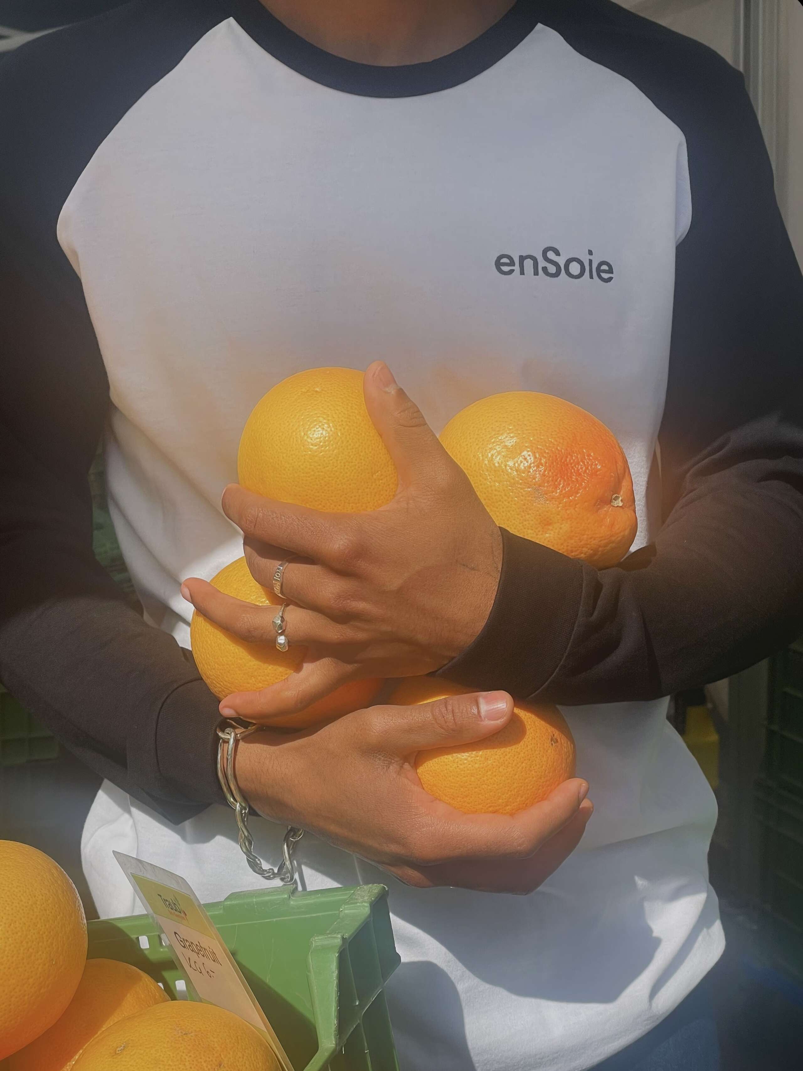 Picture of a man holding four oranges in his arms