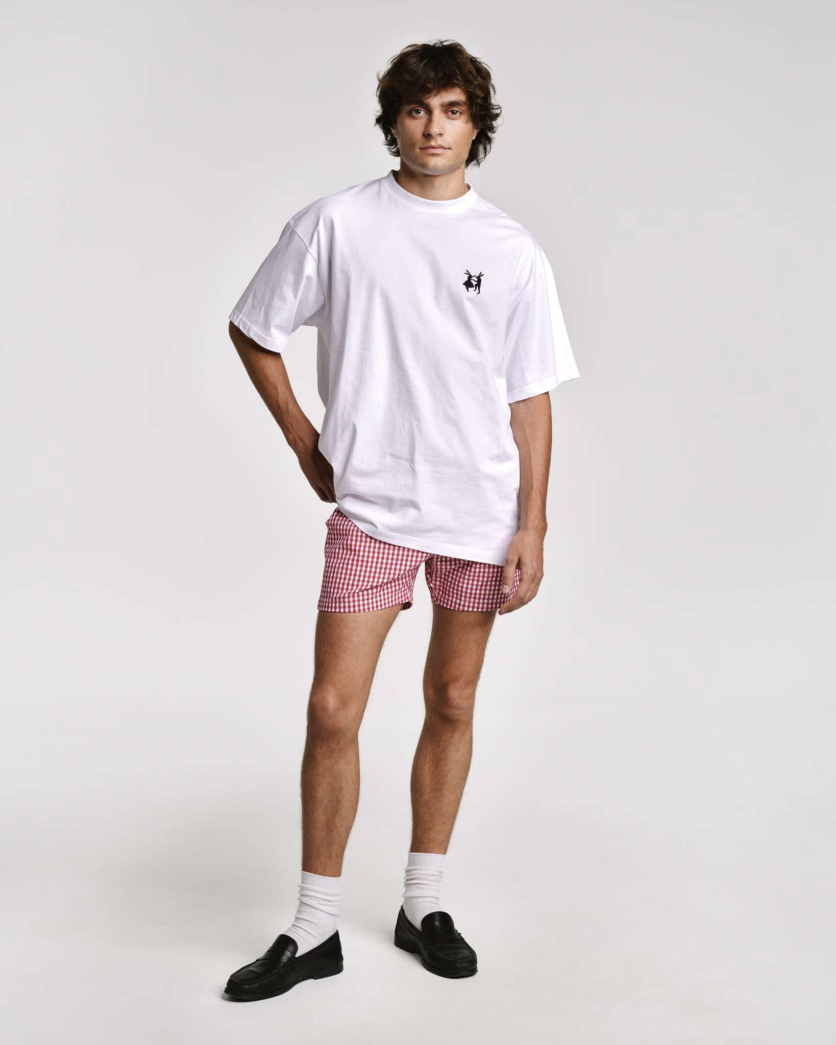 Model wearing Tshirt with the embroidered rabbits logo and Allen shorts in red vichy
