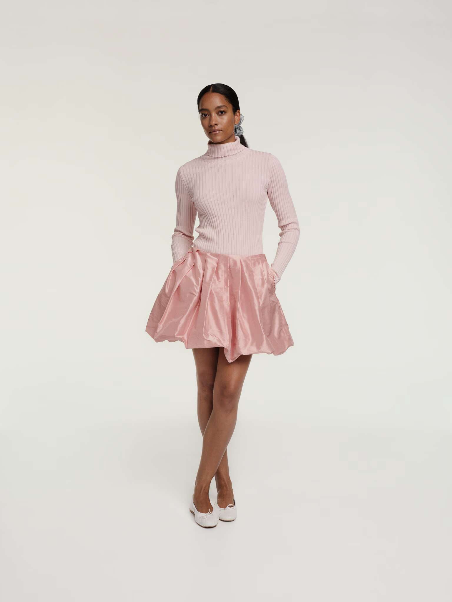 Picture of a women wearing a soft pink silk skirt and turtleneck
