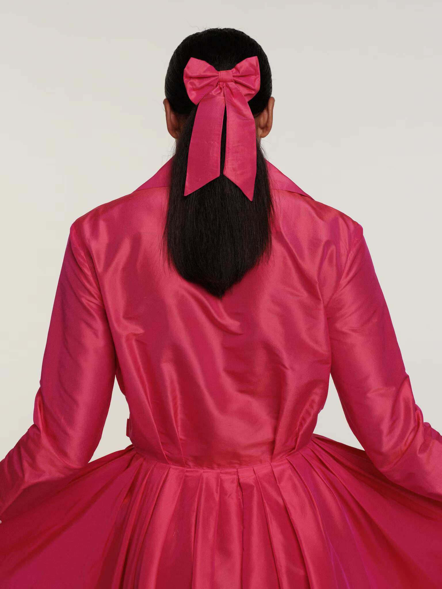 Picture of a women wearing a pink silk dress.