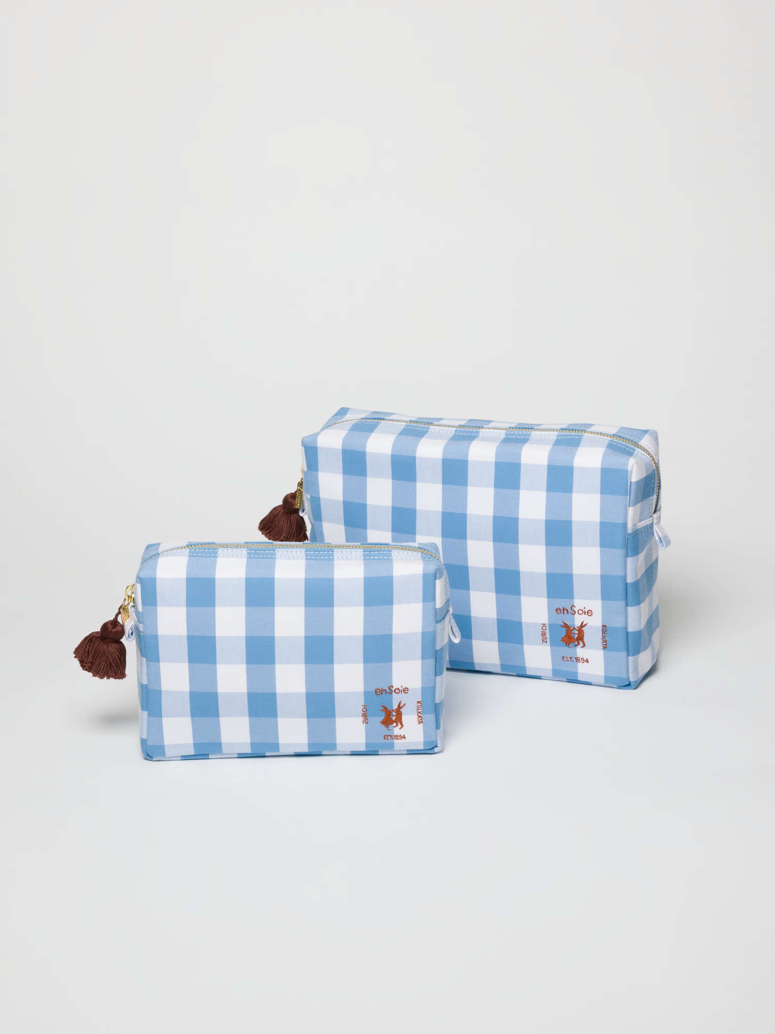 toiletry cases in two sizes in vichy check calm blue light blue with brown tassel