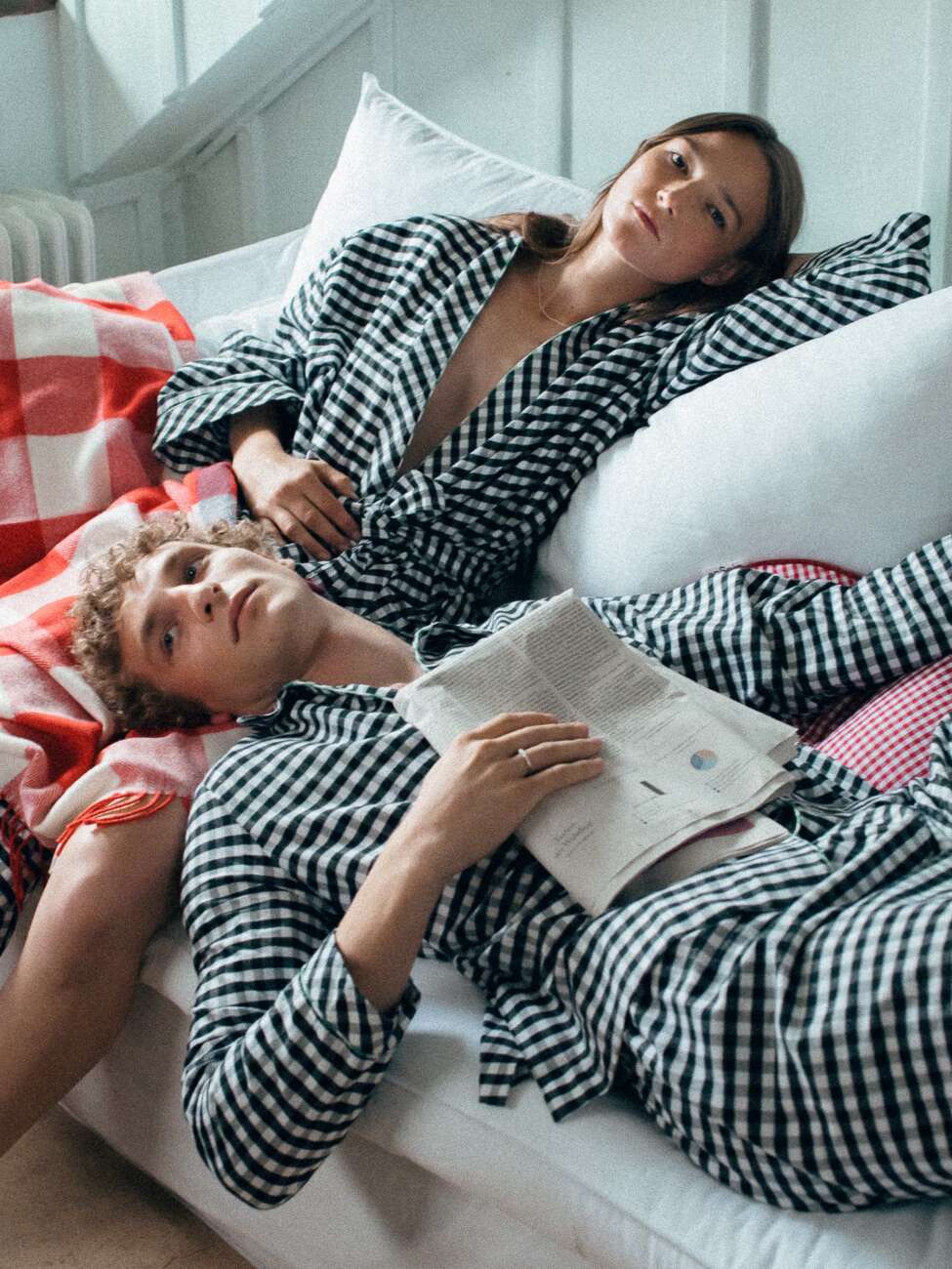 Picture of a couple on a bed wearing light black pyjamas