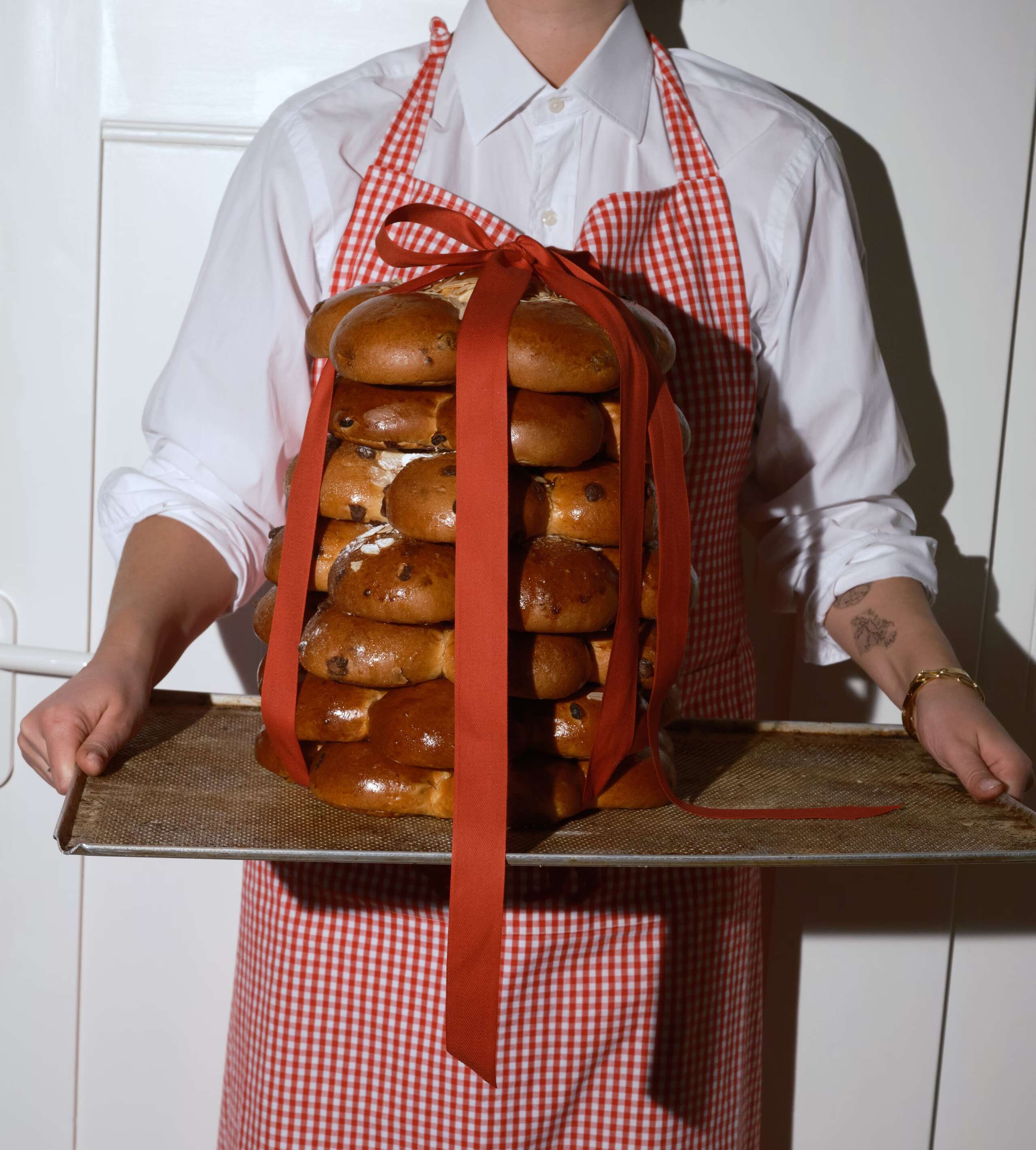 Bild von einer Person, die mehrere Dreikönigskuchen trägt.