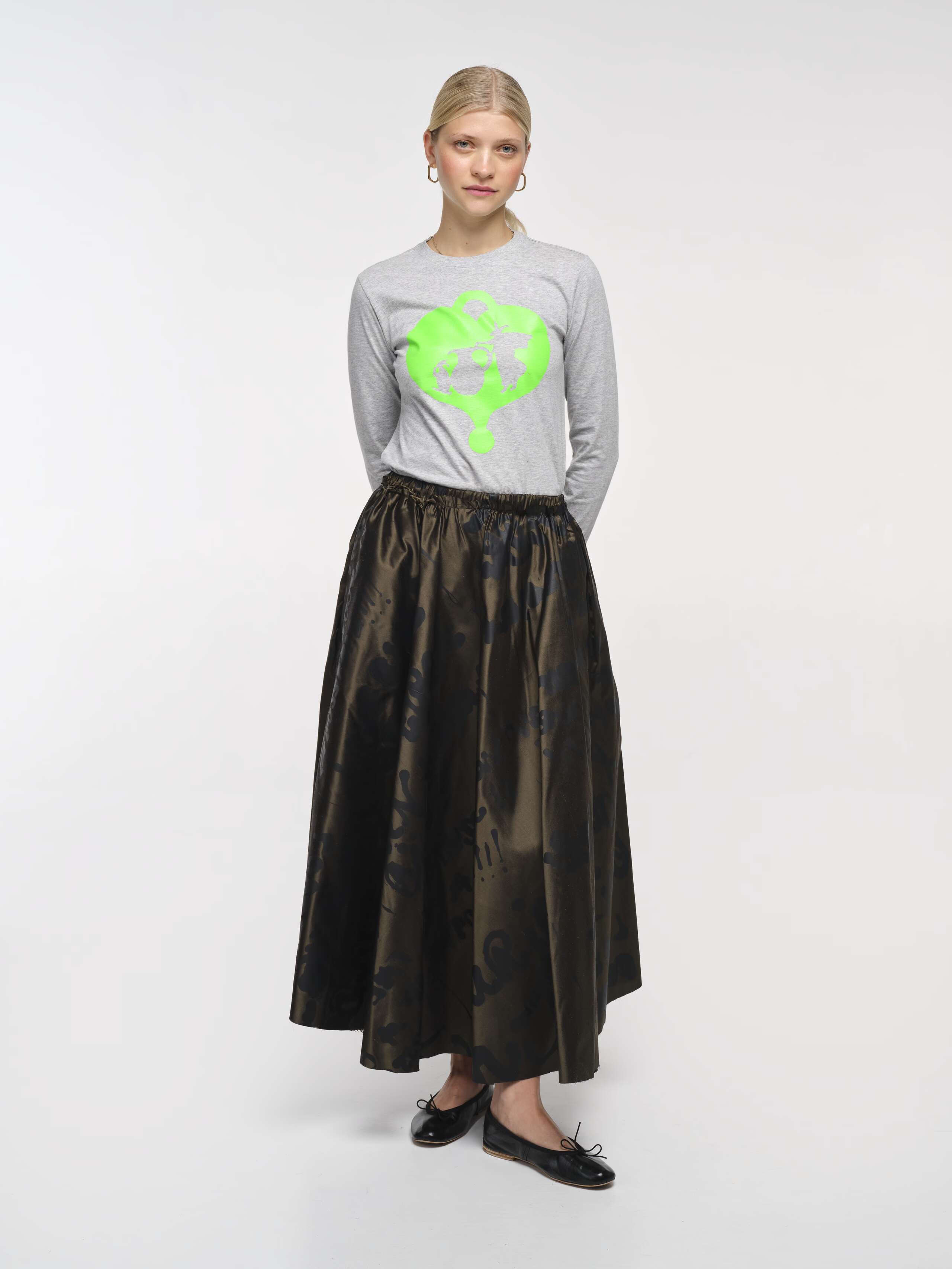 Picture of a women wearing a khaki coloured skirt in combination with a grey longsleeves shirt