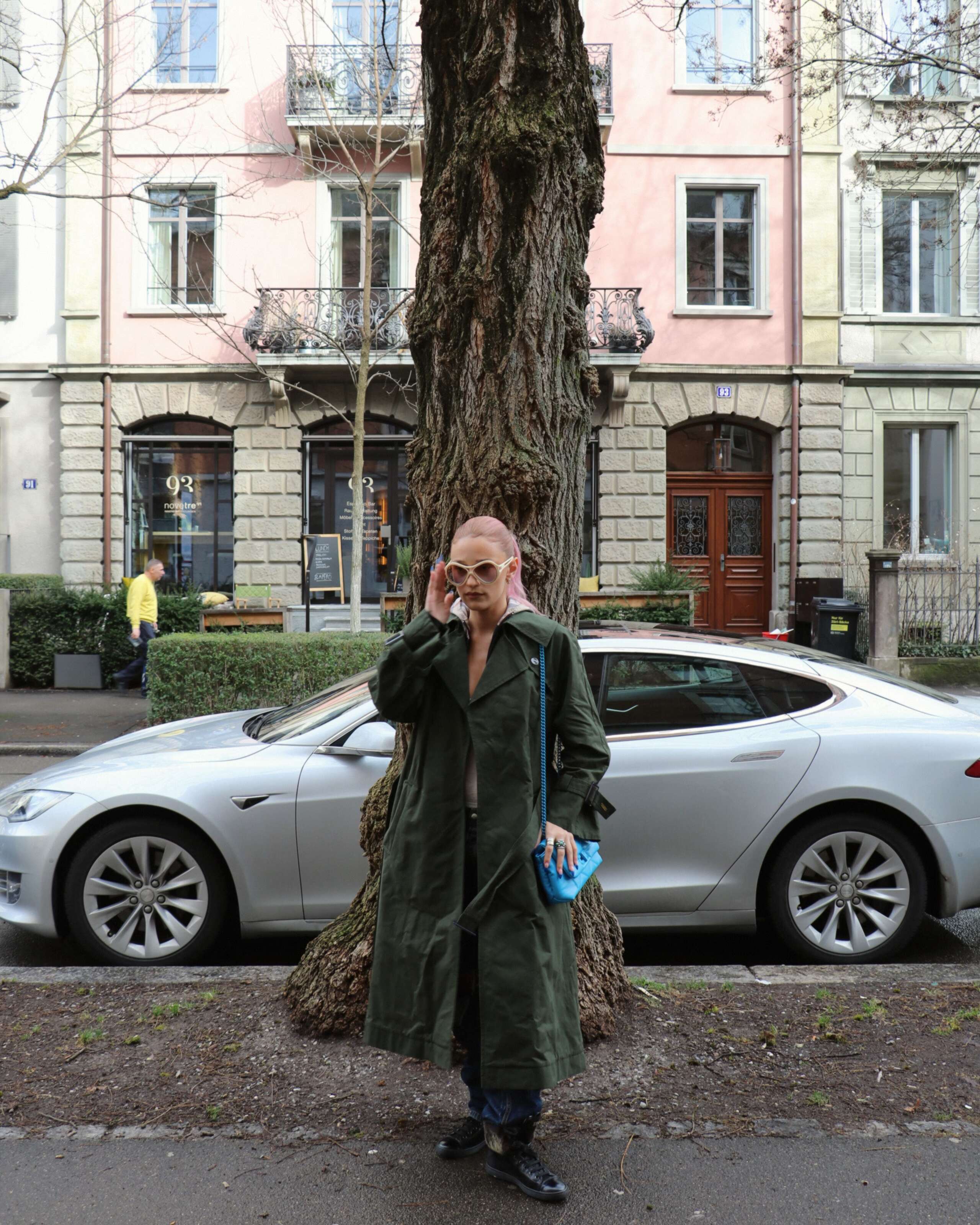 Picture of a women wearing a green enSoie trench coat
