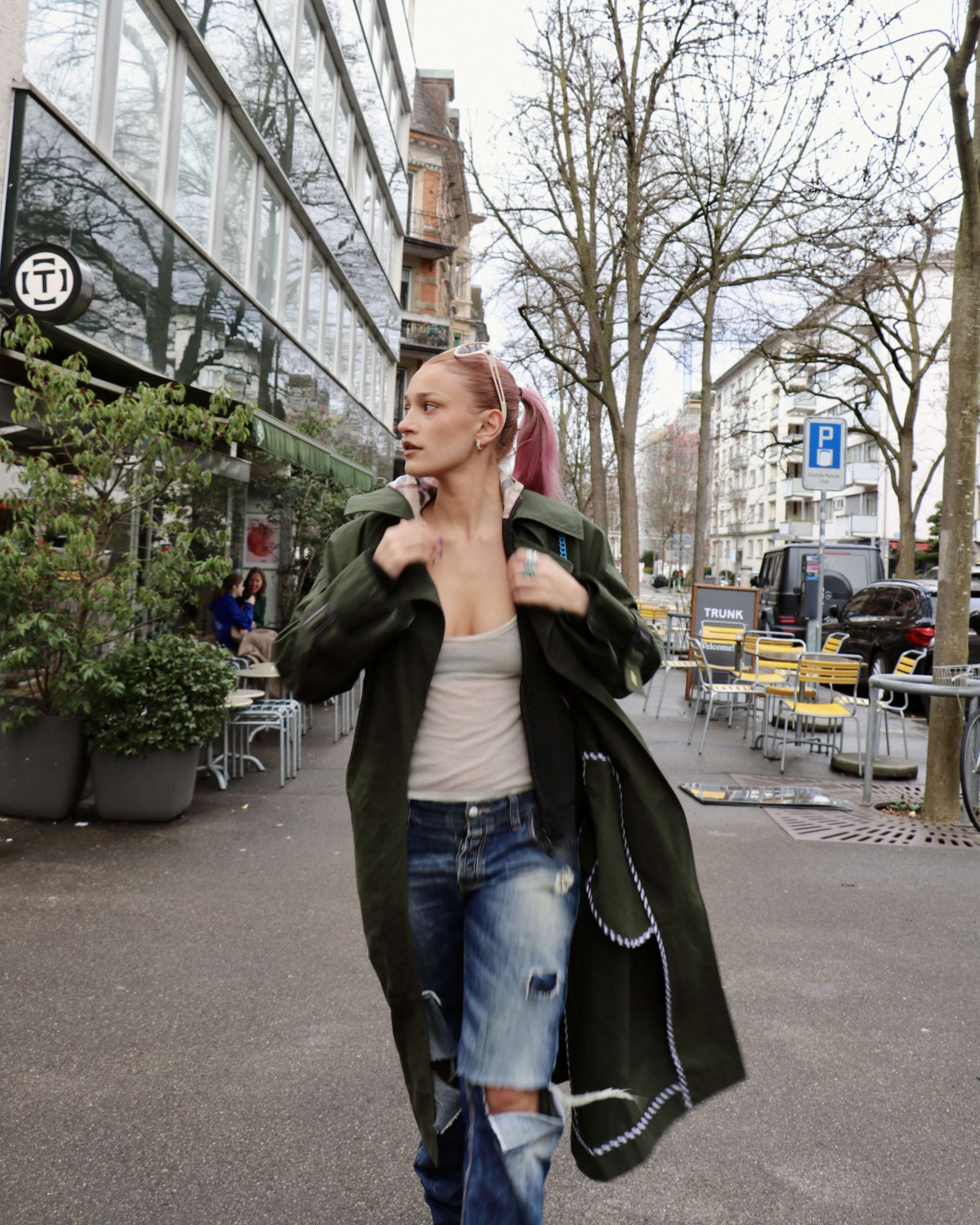 Picture of a women wearing a green enSoie trench coat