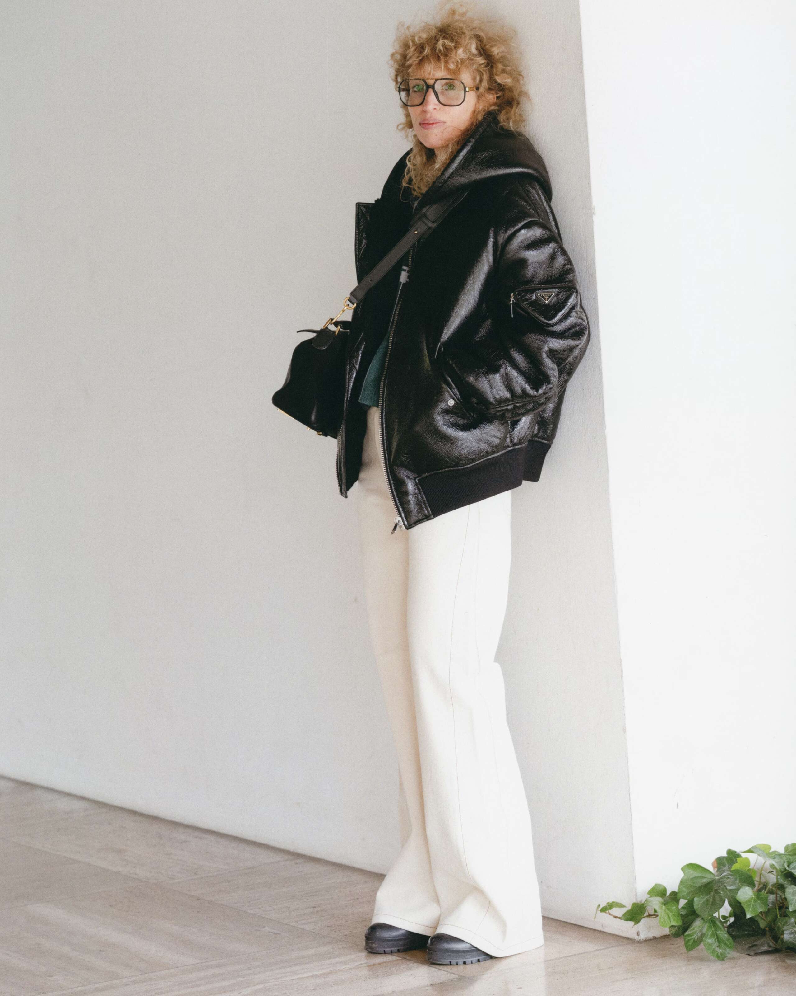 Picture of a women wearing white jeans and a black leather jacket. 