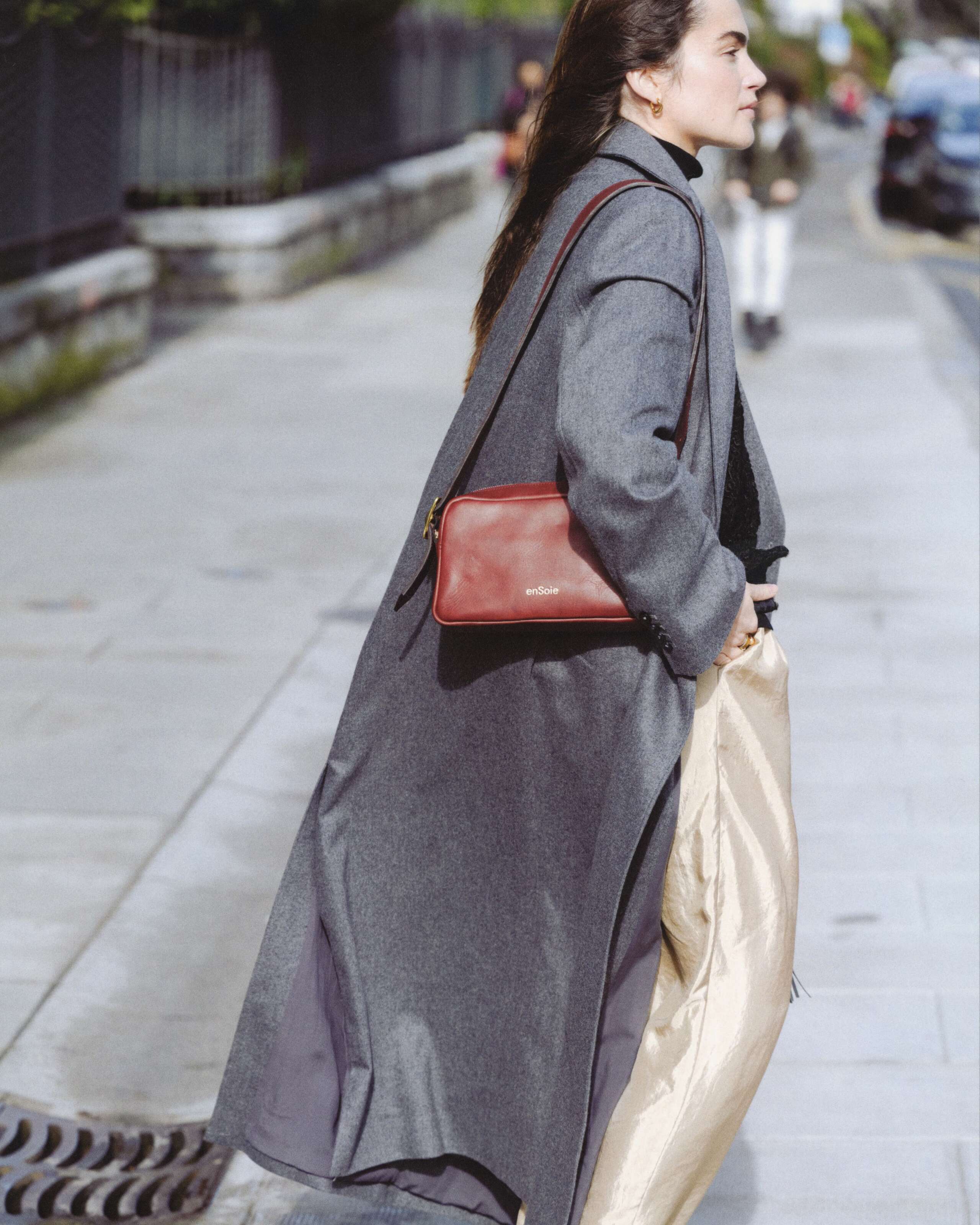 Picture of a women carrying a small red enSoie leather bag
