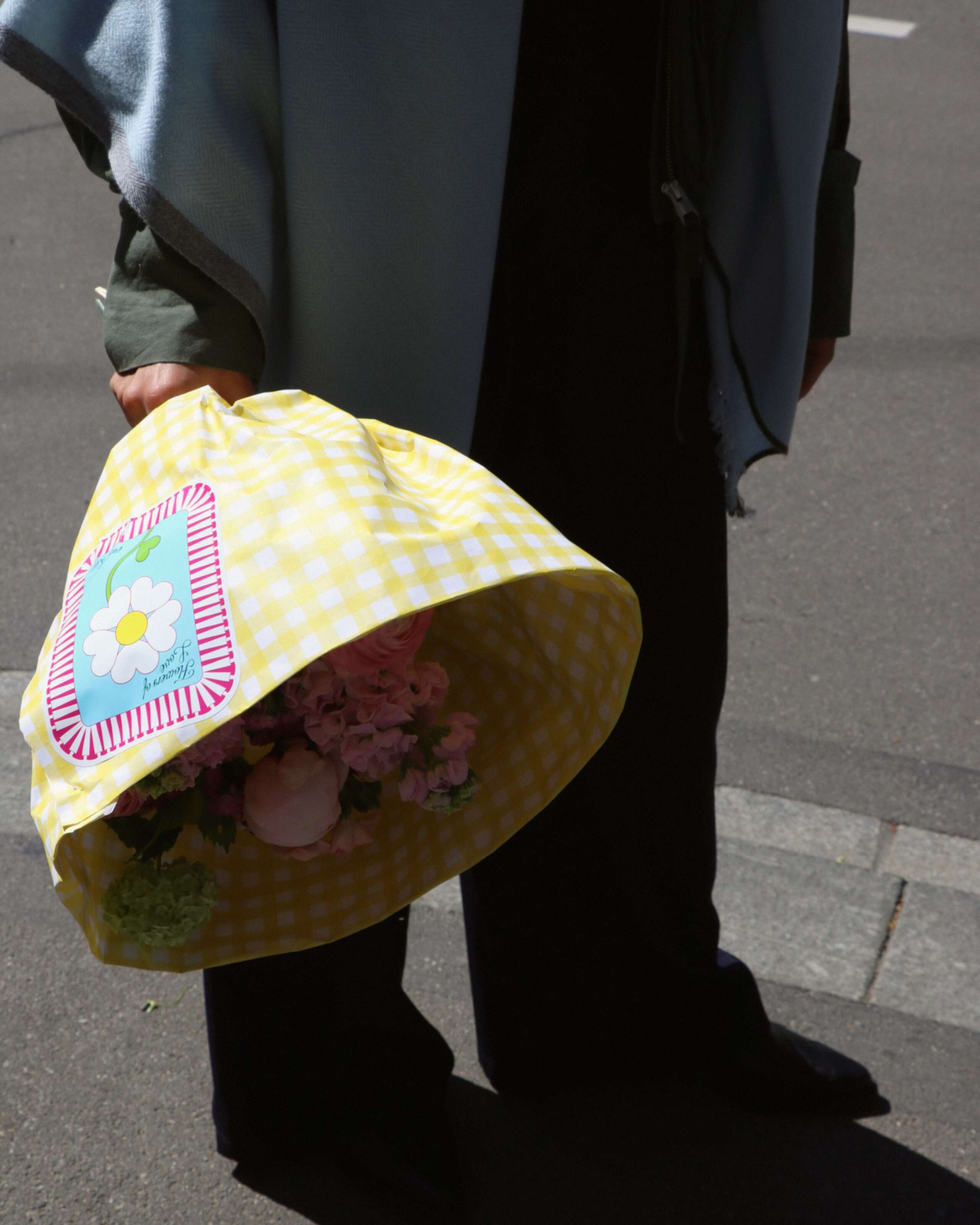 Picture of a women holding a flower bouquet wrapped in a yellow paper